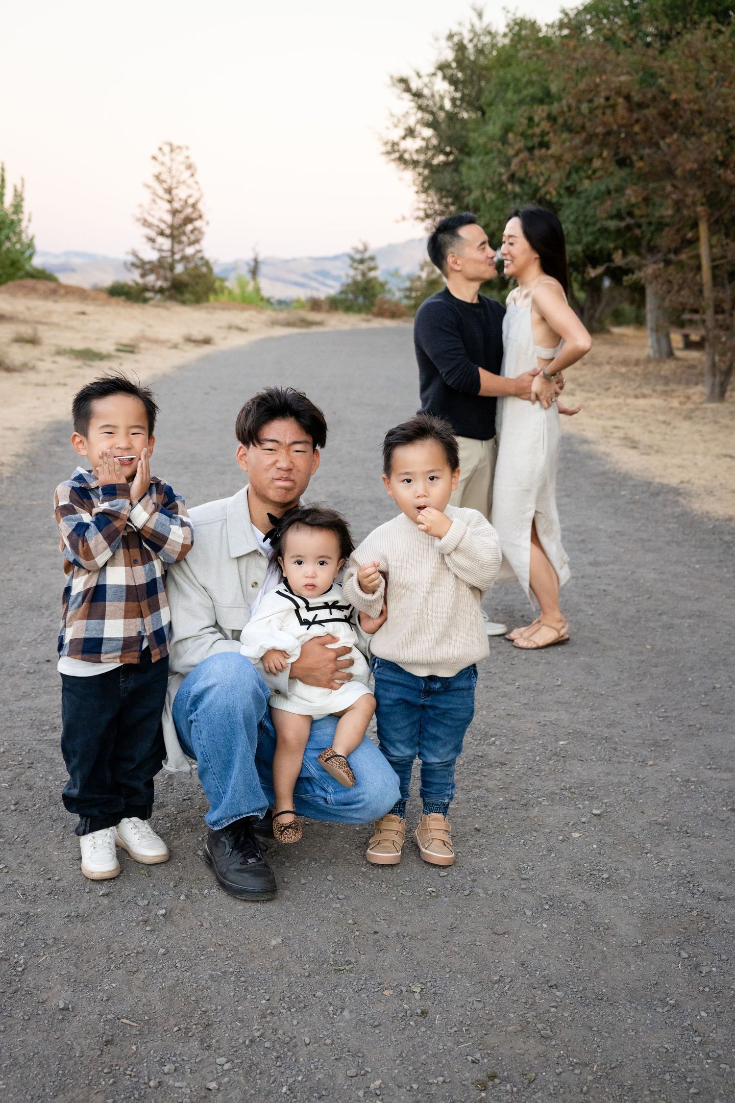 Candid family moments captured on a dirt path outdoors.