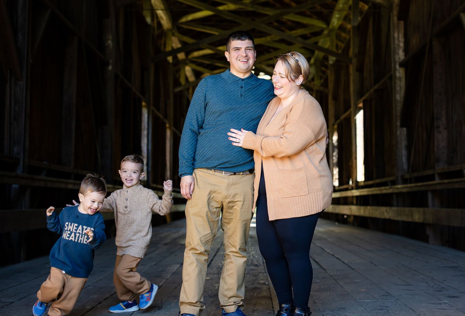 Group photo session inside a dimly lit barn with dramatic lighting.