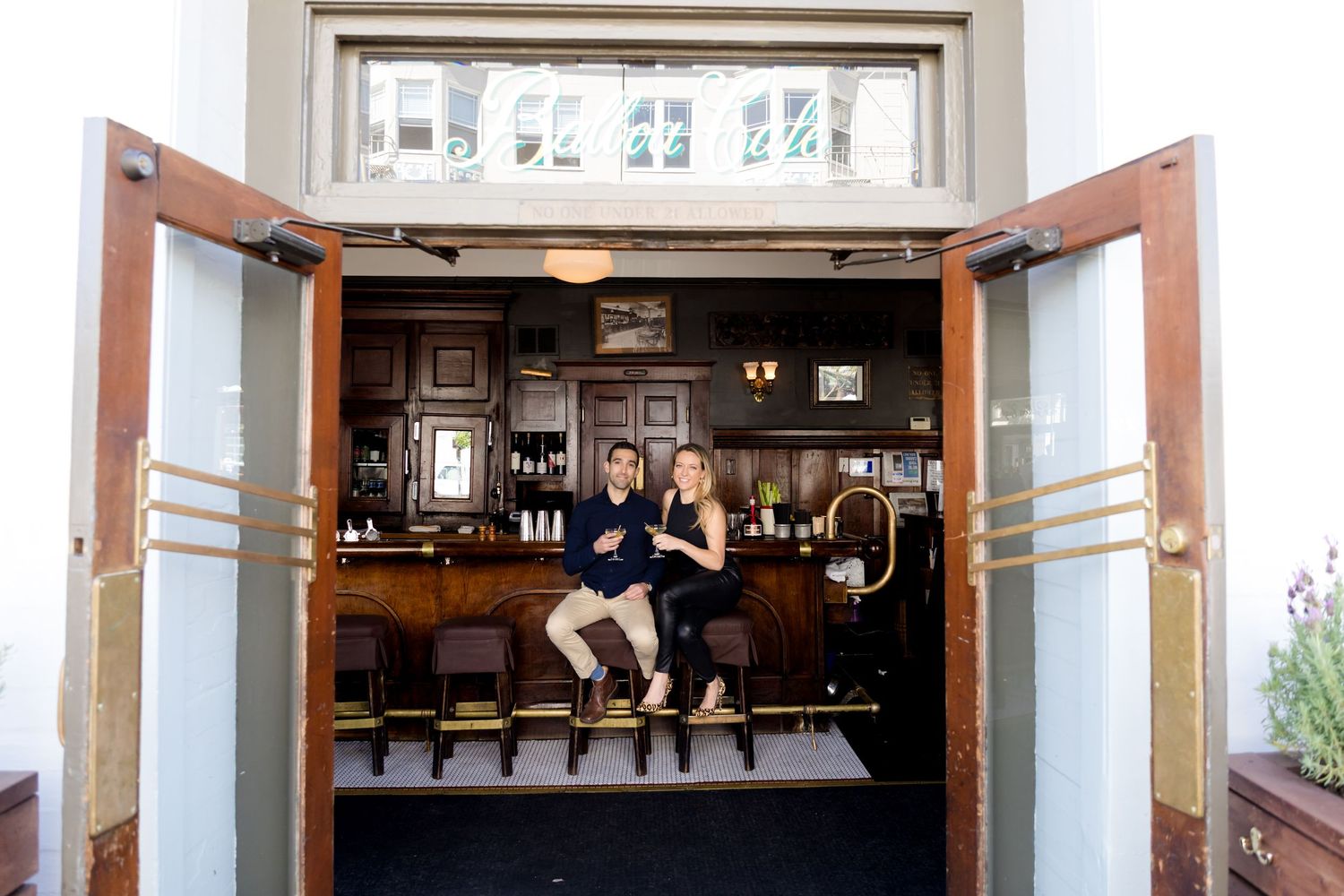 Interior view of a classic pub or bar with wooden decor, glass display cases, and vintage photographs on the walls.