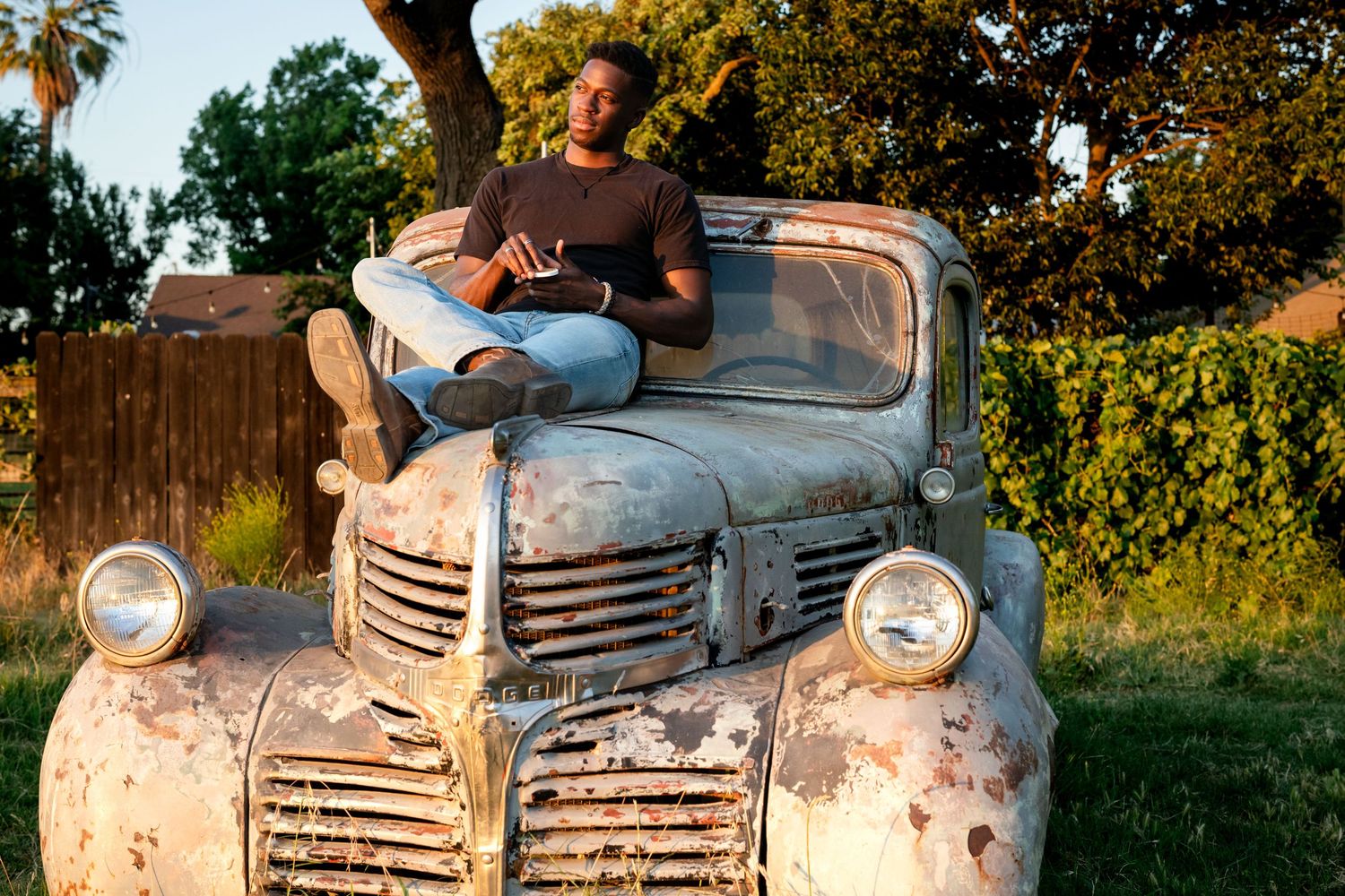 Vintage white Plymouth automobile with rustic patina photographed during sunset.