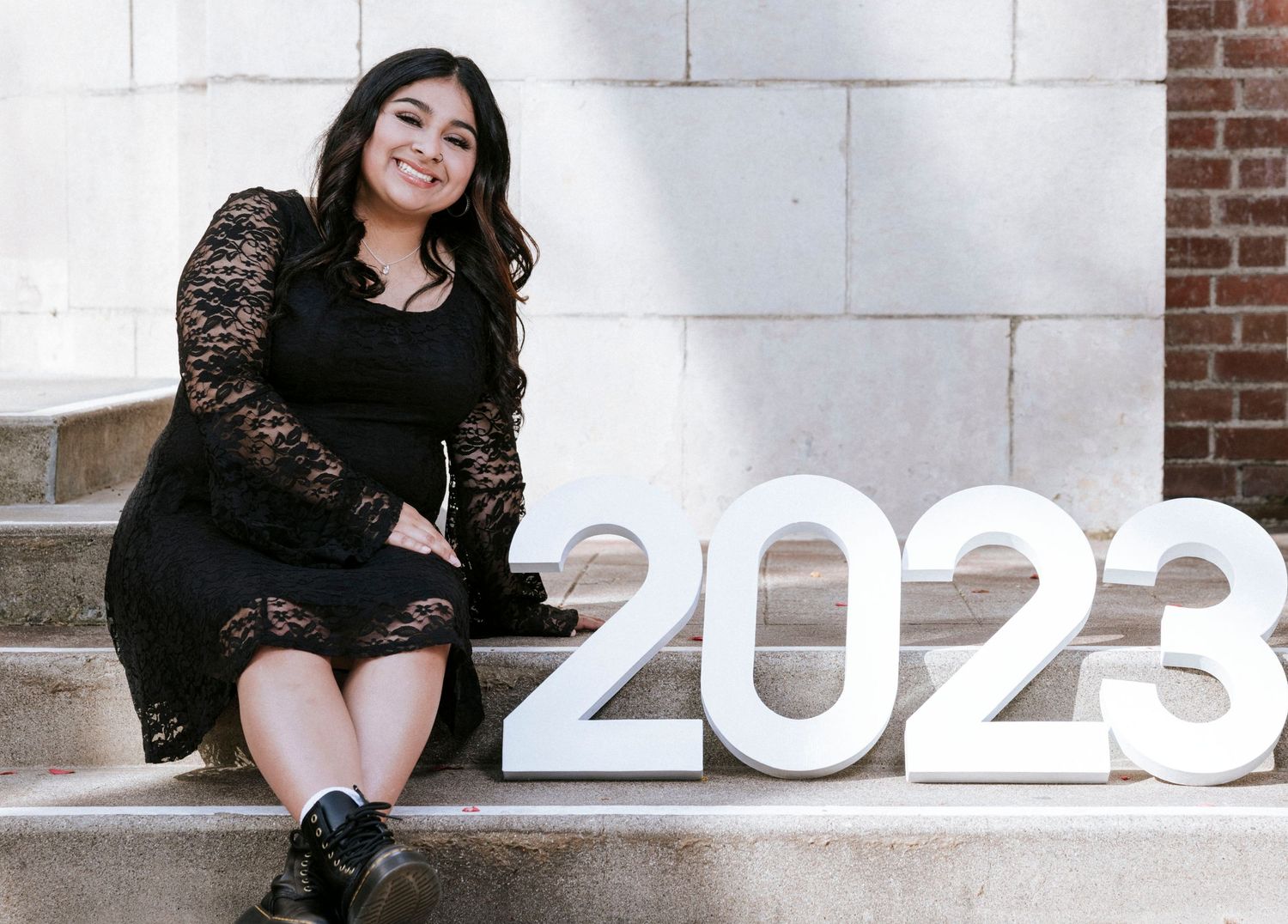 Portrait session against white wall with large 2023 text display.