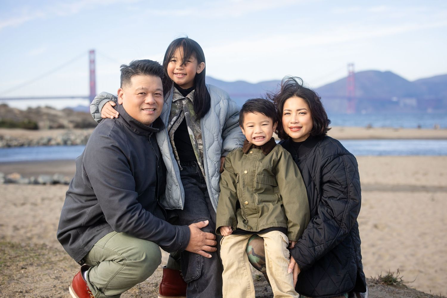 Family enjoying a relaxed moment together on a beach near San Francisco Bay.