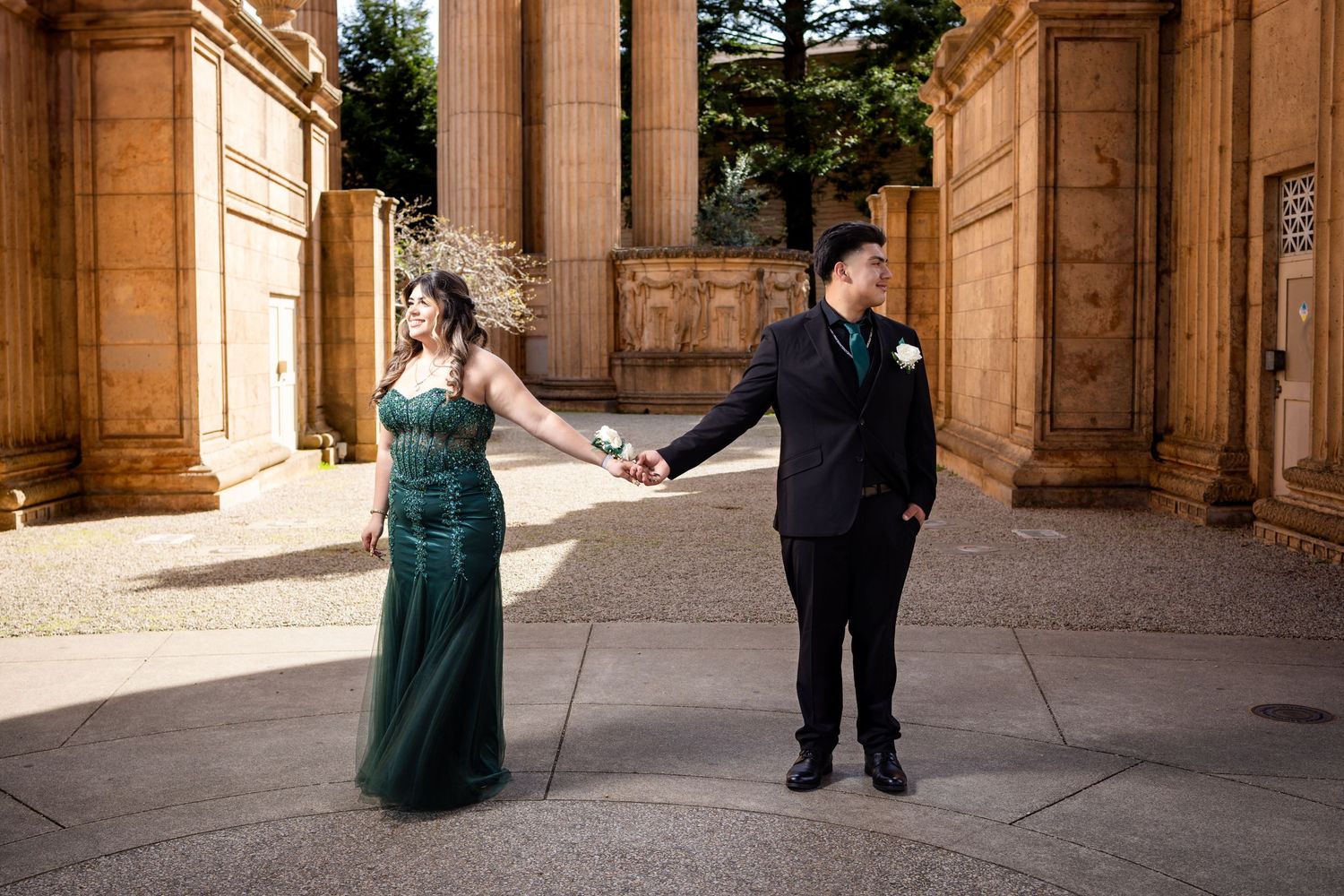 Couple dancing and posing between classical columns at historic building.
