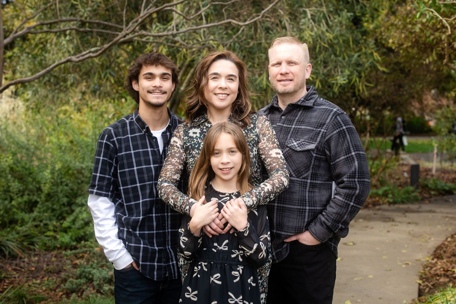 Group portrait session in a park with autumn foliage in the background.