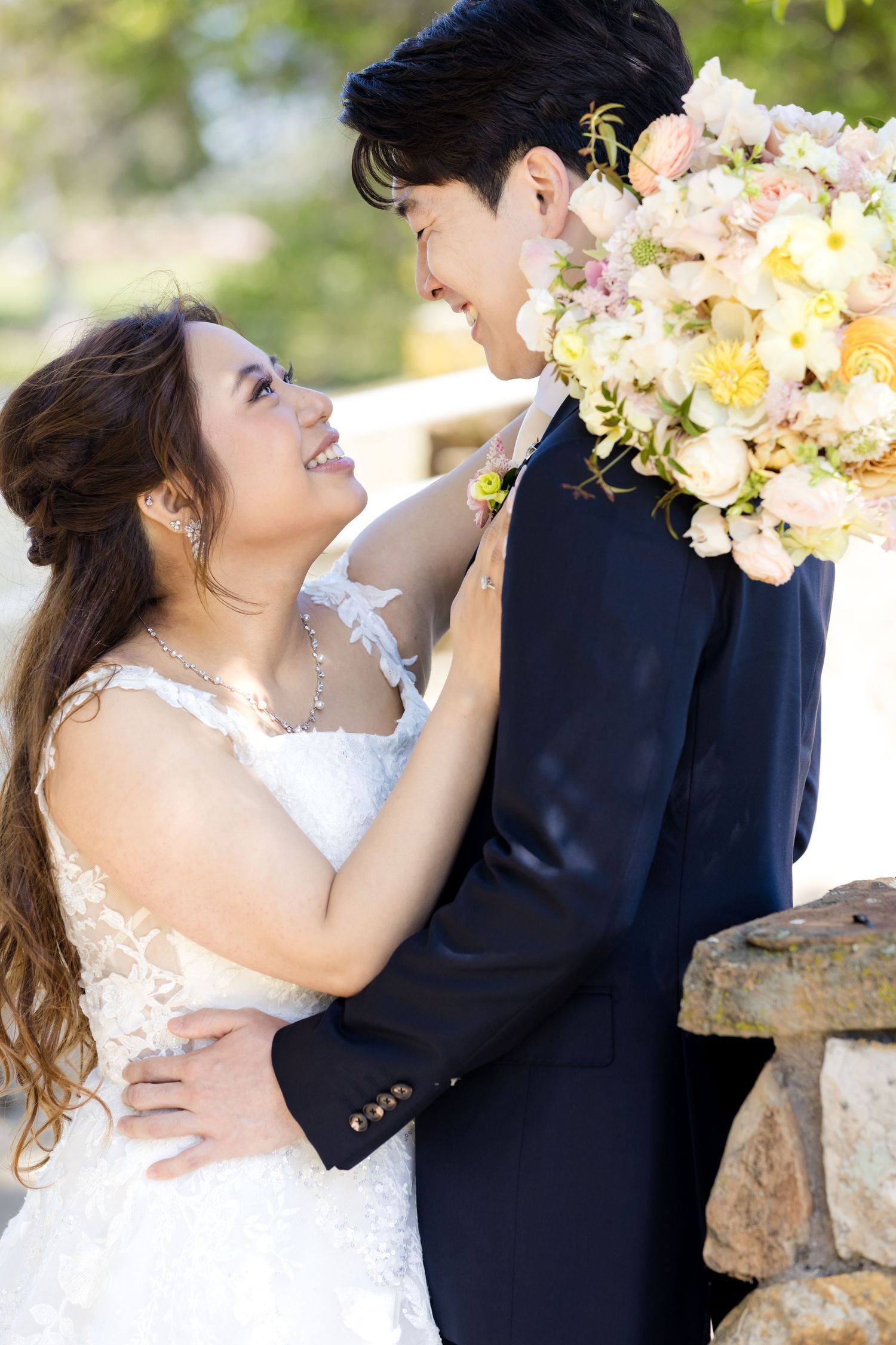 Romantic wedding portrait sequence with elegant floral bouquet against stone backdrop.