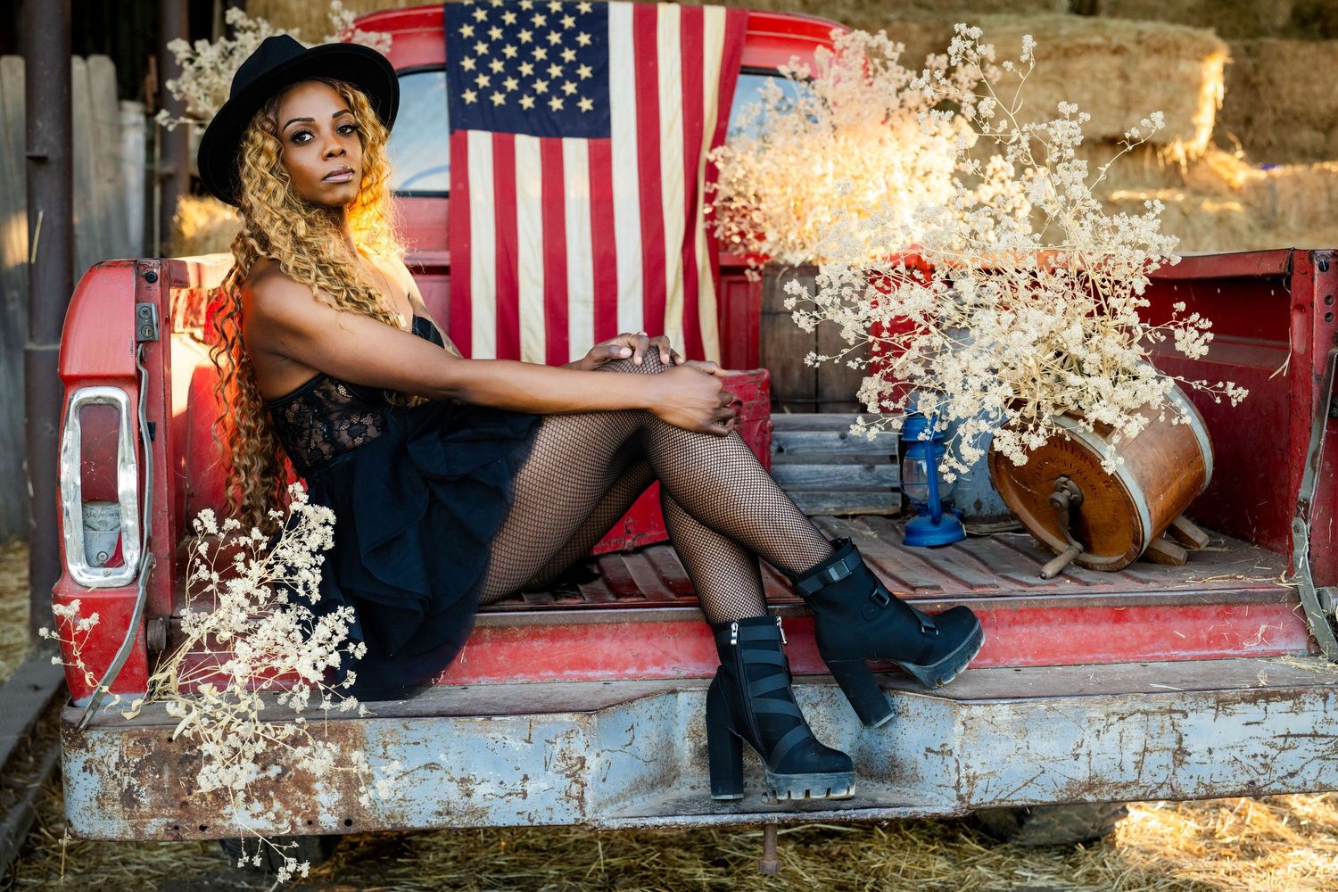 American flags hang in the background as a person sits casually on a rustic wooden bench.