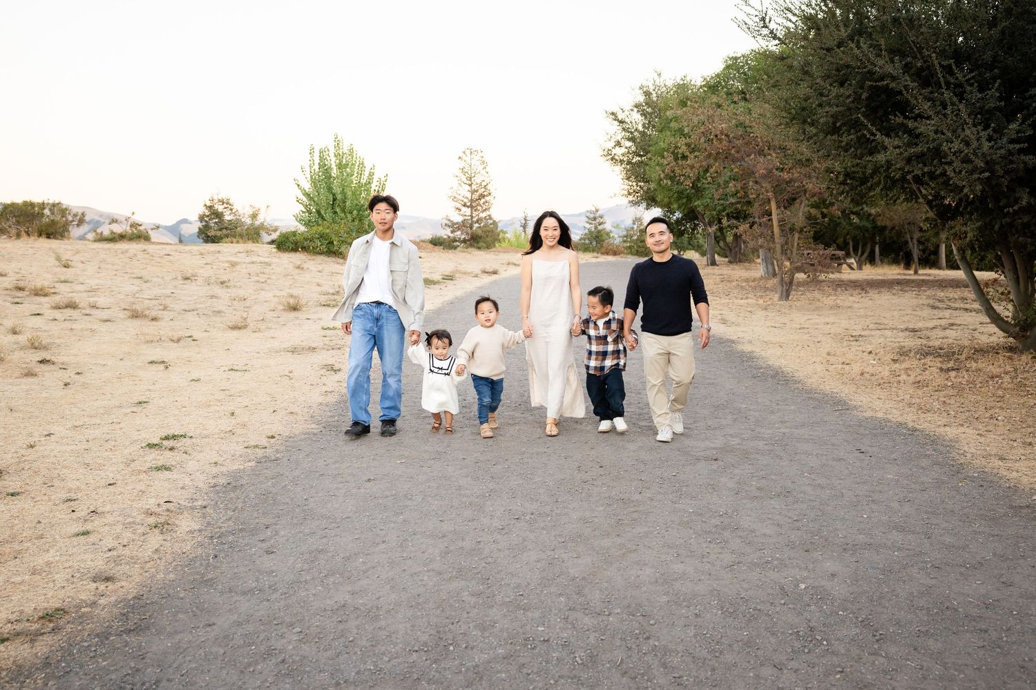Family walking together on a dirt path in a natural setting.