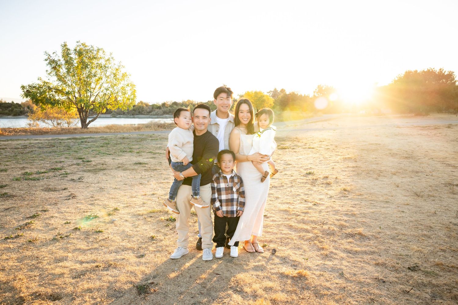 Family walking together in a field during golden hour sunset.