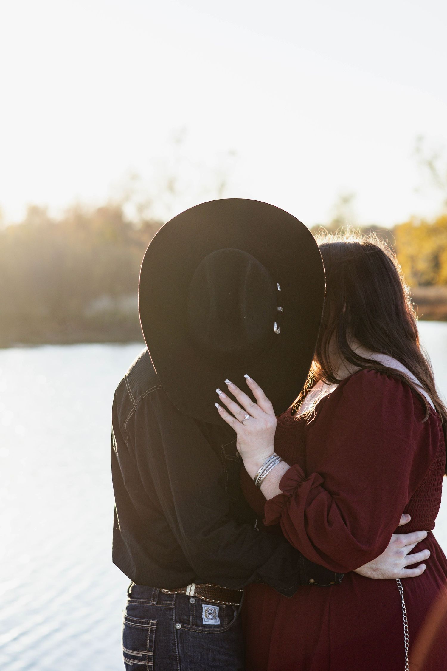 A series of romantic silhouettes showing a couple embracing and kissing against a bright backlit sky at sunset.