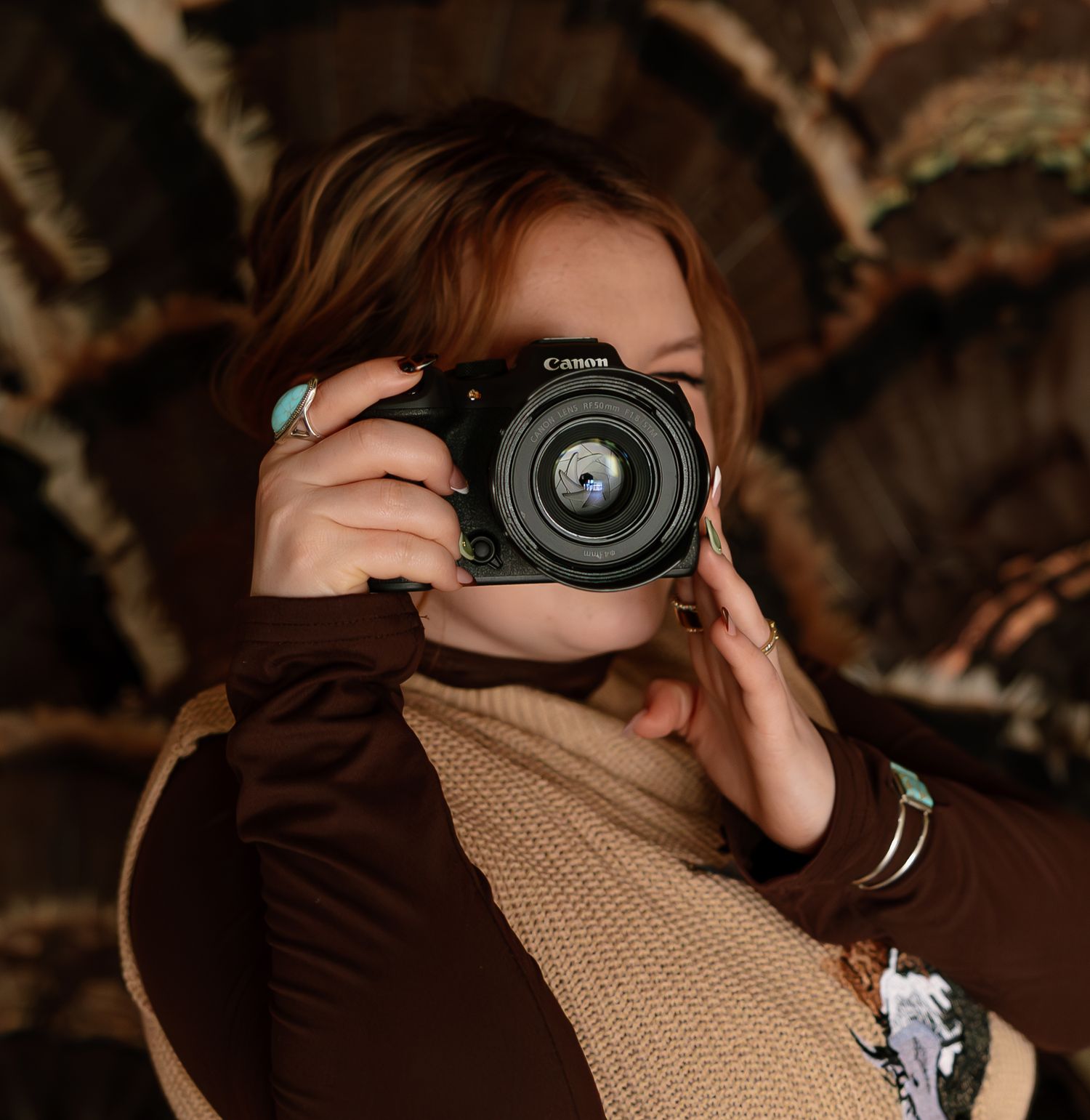 A sequence of close-up shots showing a camera being held and positioned against a brown knitted background.