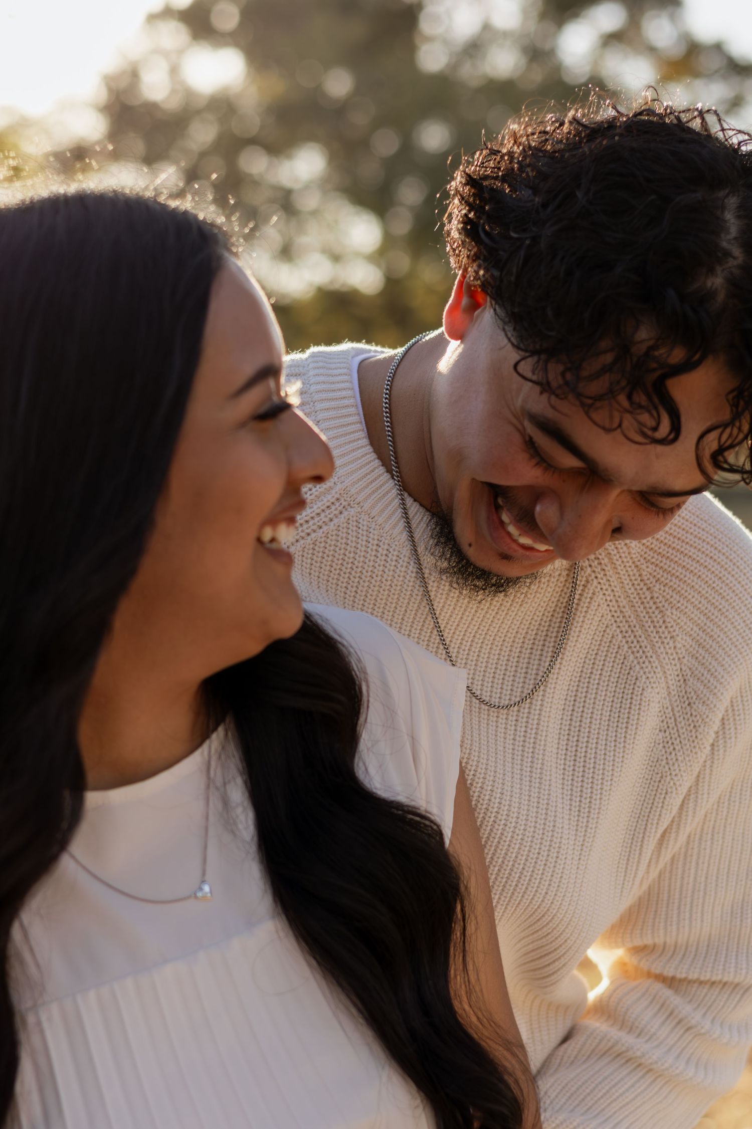 Romantic couple sharing intimate moments together outdoors in soft natural lighting.
