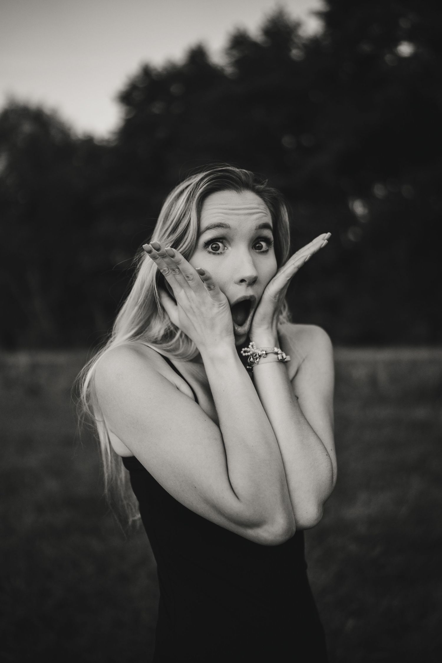 Black and white portrait showing playful expression outdoors.
