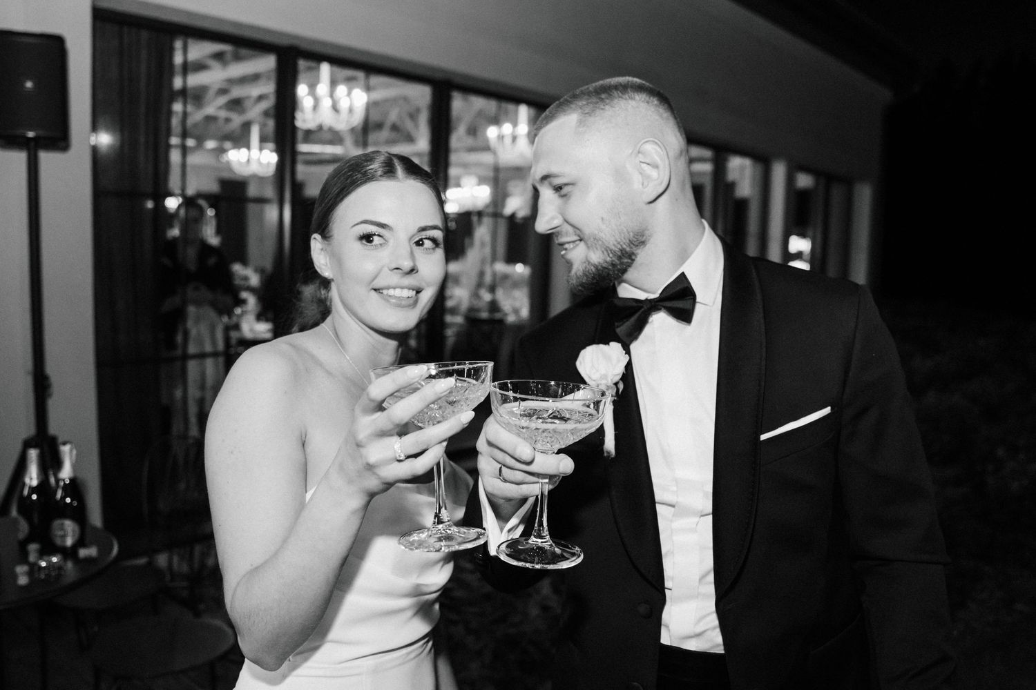 Wedding reception scene with elegant formal attire and cocktail glasses.