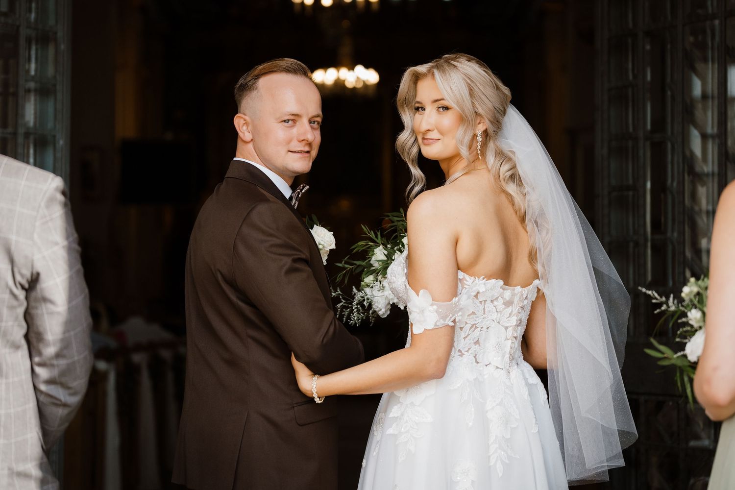 A couple shares a joyful moment during their wedding ceremony in an elegant indoor venue.