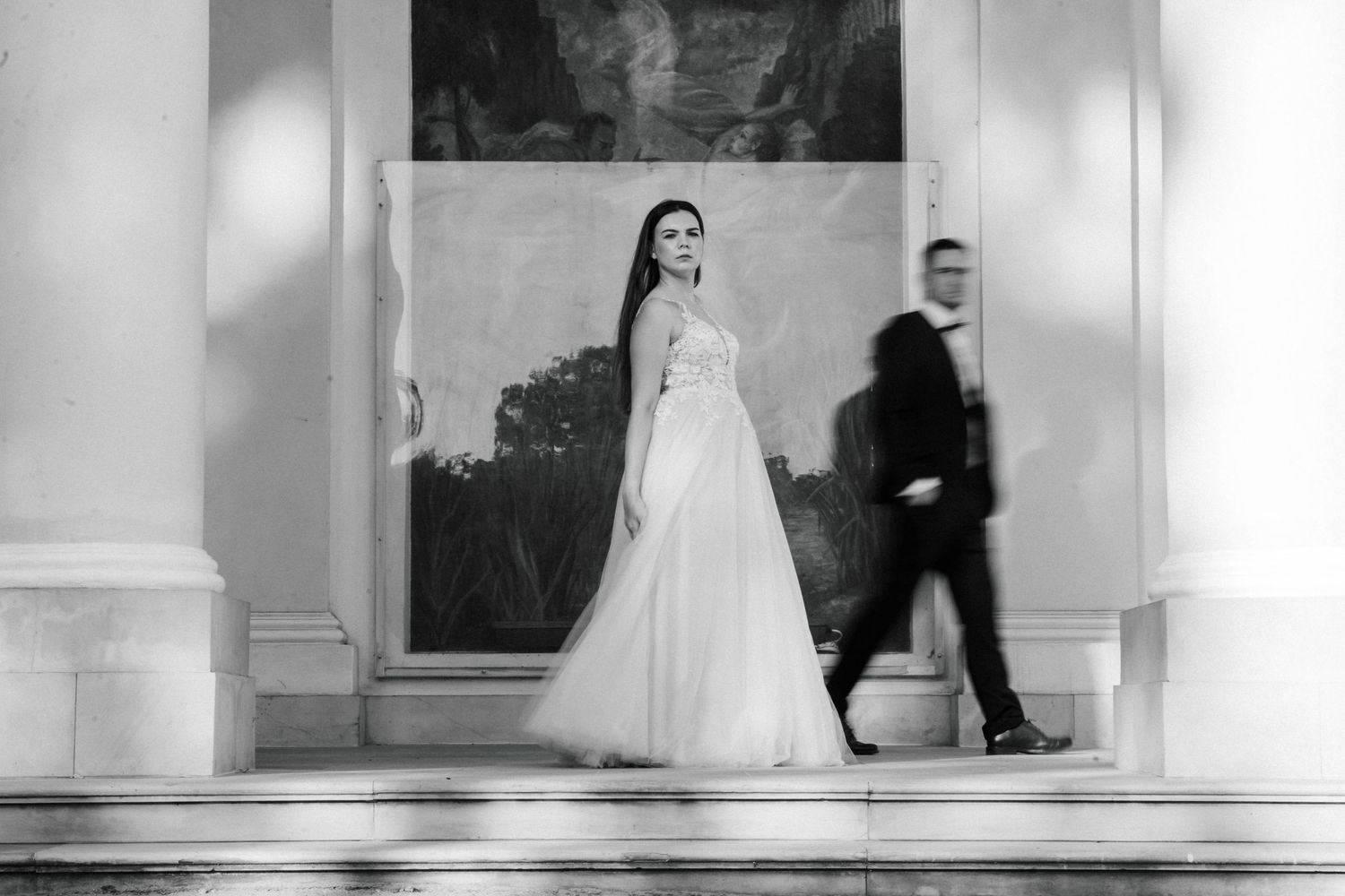 Black and white wedding photograph showing movement in an elegant indoor setting.