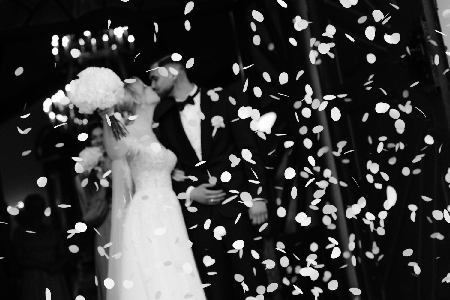 Wedding celebration scene with confetti falling against a dark background.