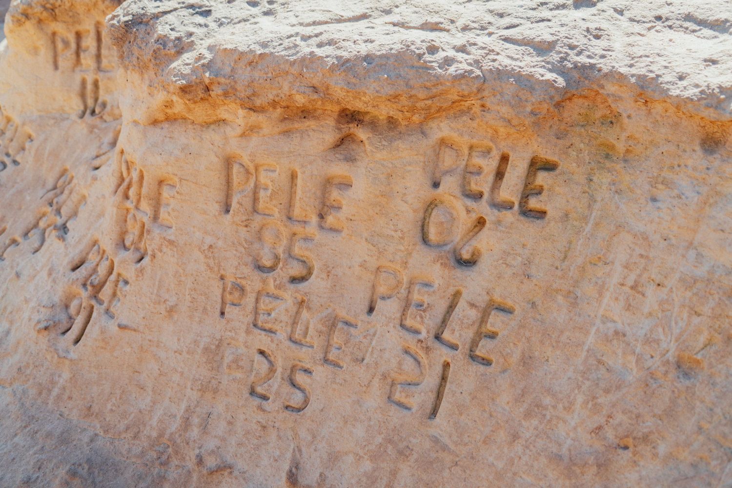 Weathered rock inscription with faded text carved into limestone surface.