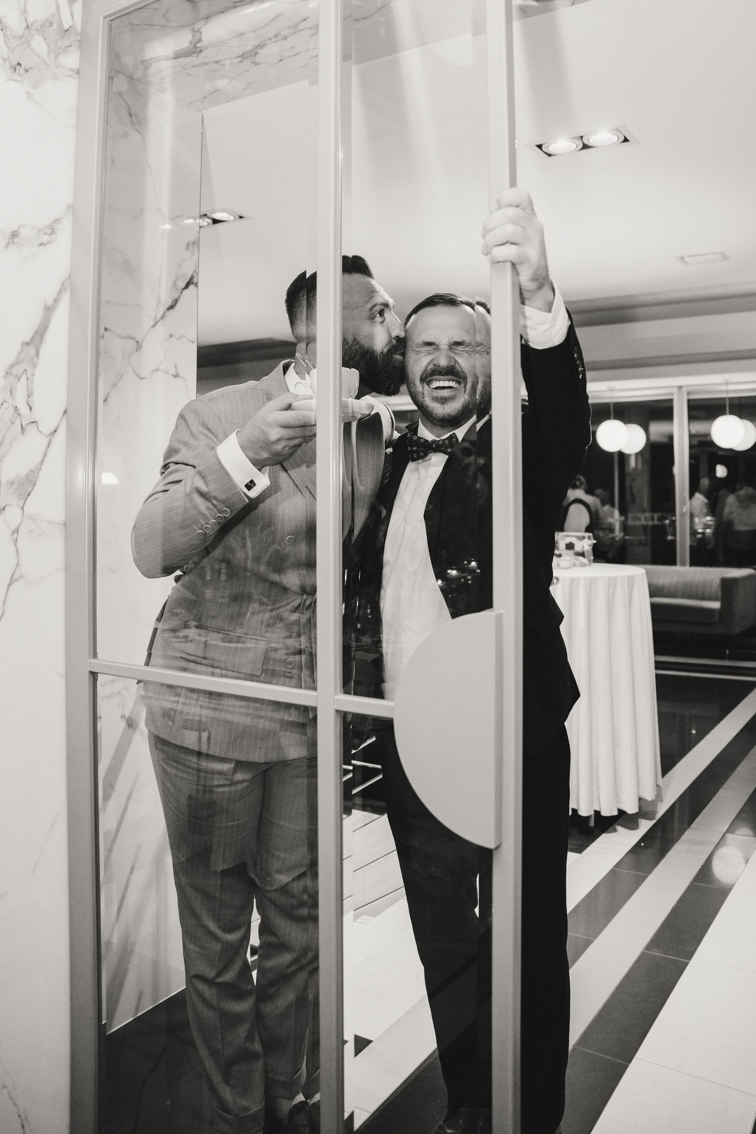 A sequence of black and white photos showing a person laughing and gesturing through a window or glass panel.