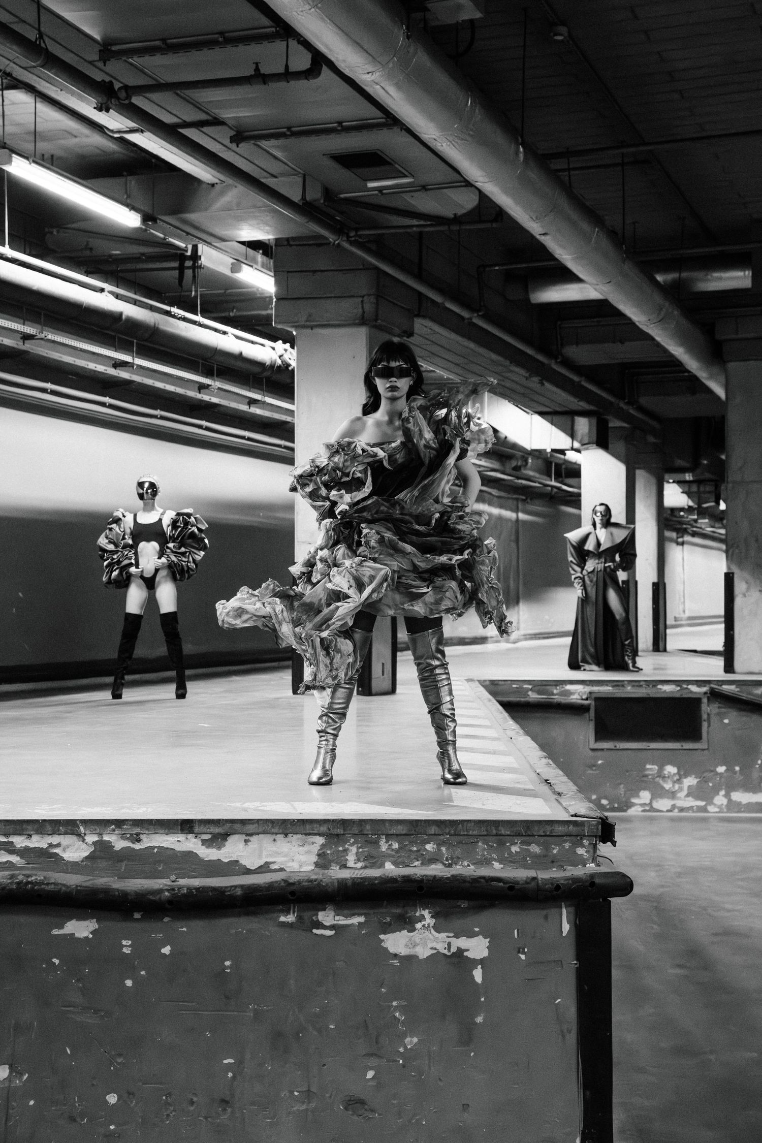A sequence of black and white photos showing a skateboarder performing an ollie trick over a ledge in an indoor space.