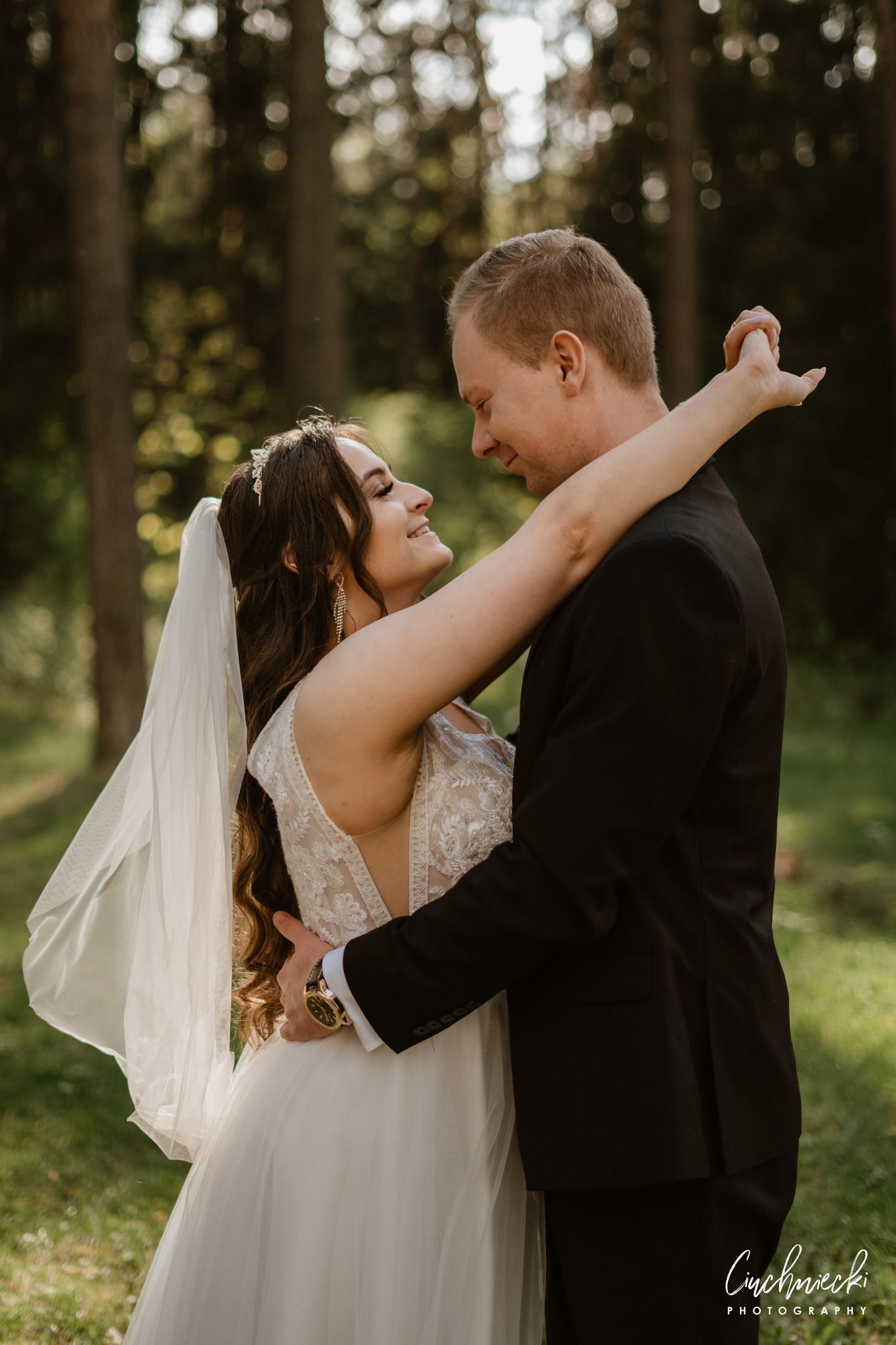 Romantic wedding photos taken in a sunlit forest setting.