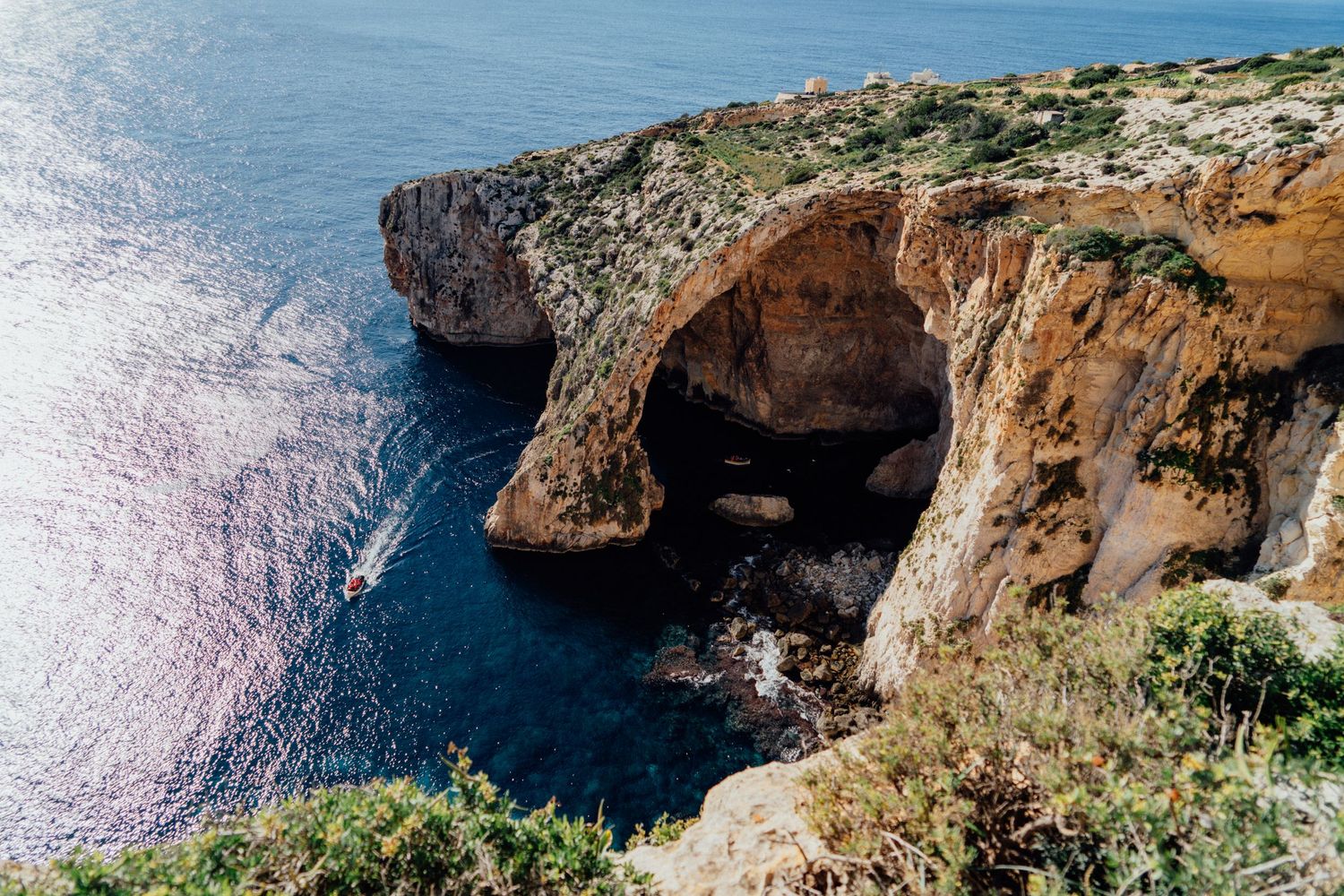 Dramatic limestone cliffs and rock formations rise above the crystal clear Mediterranean Sea.