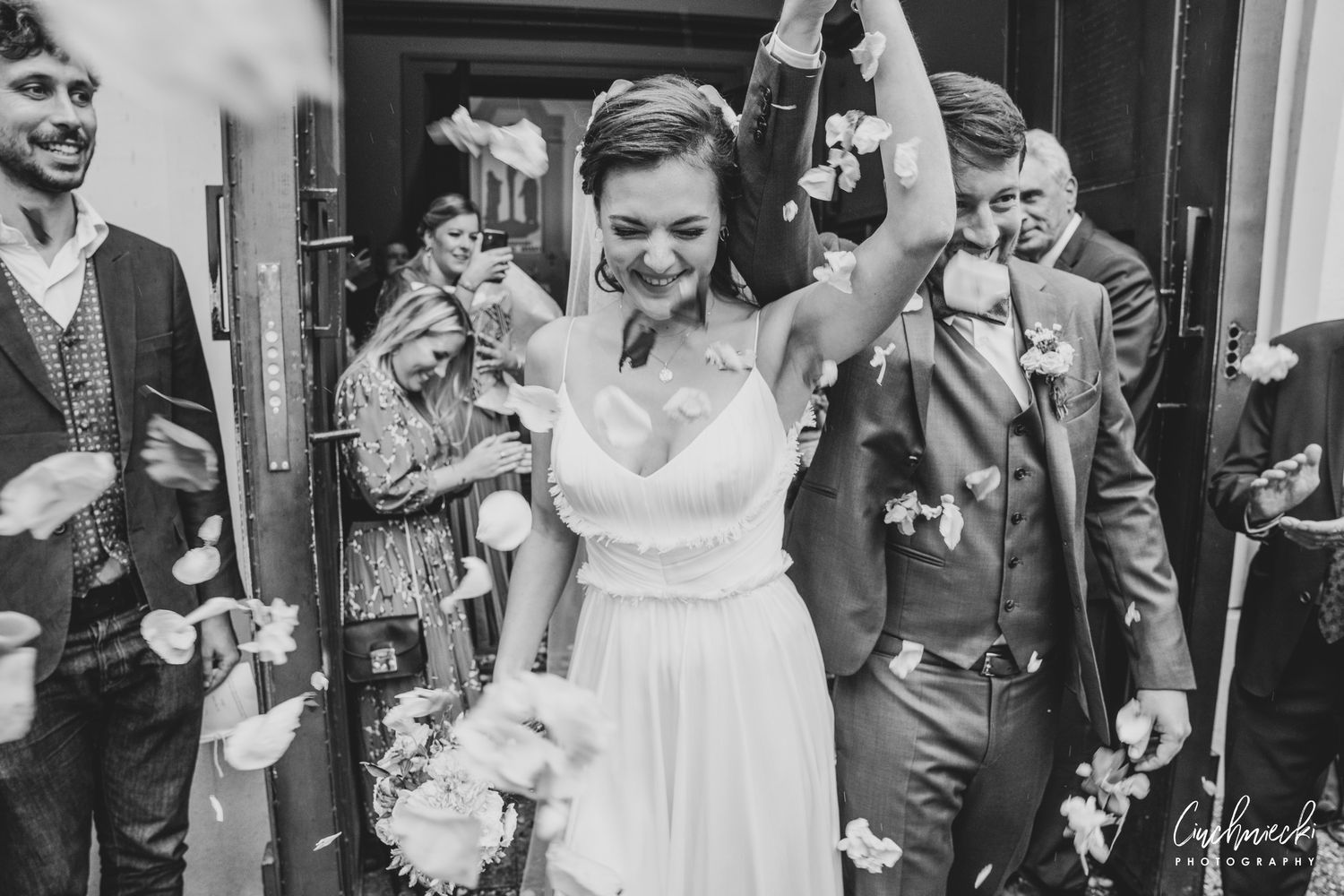 Black and white photos of wedding guests celebrating and laughing together.