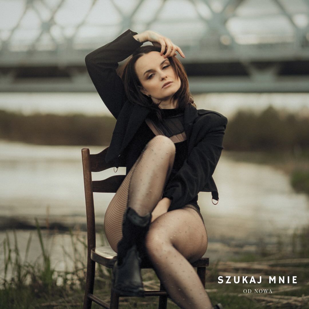Artistic portrait of a model posing on wooden chair outdoors.
