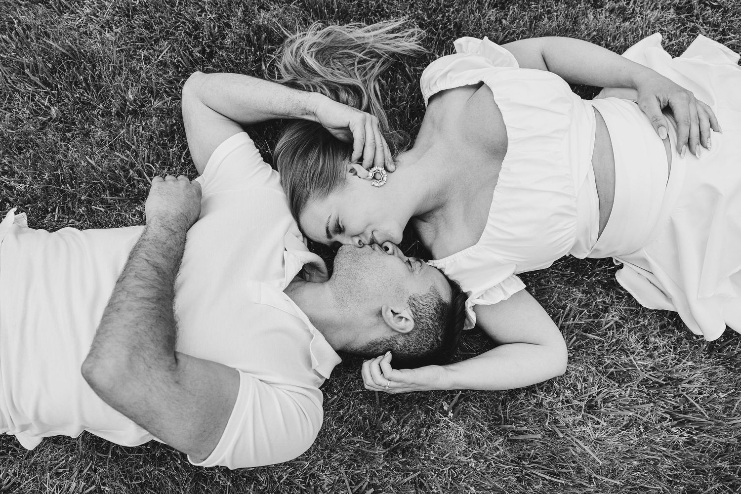A series of black and white photographs showing people lying down and relaxing in grass outdoors.