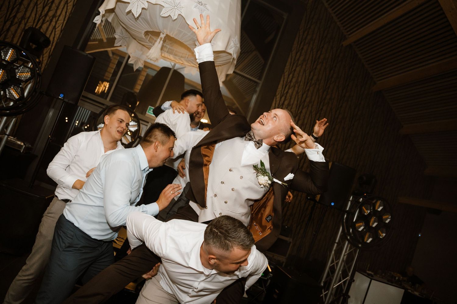 Wedding reception party guests dancing and celebrating with high energy.