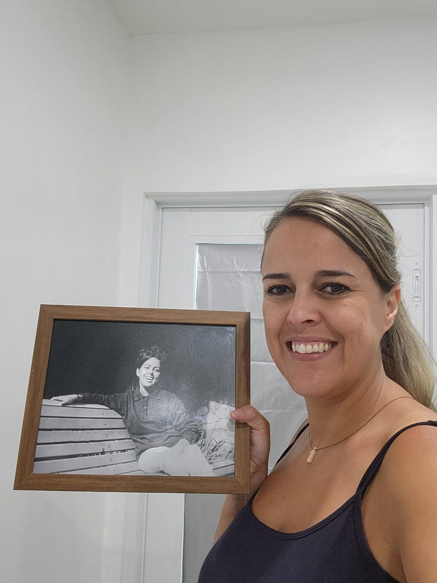 Client holding a professionally restored family photo in Miami after photo restoration service