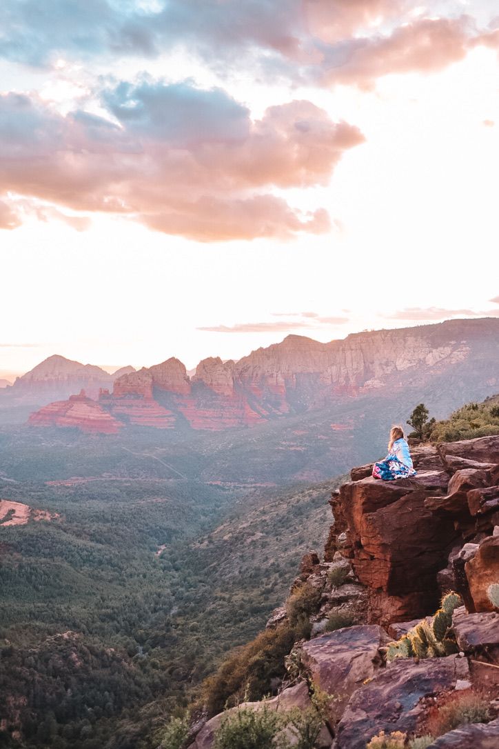 A stunning vista of red rock canyons and mountains under a pink and purple sunset sky in Sedona Arizona.