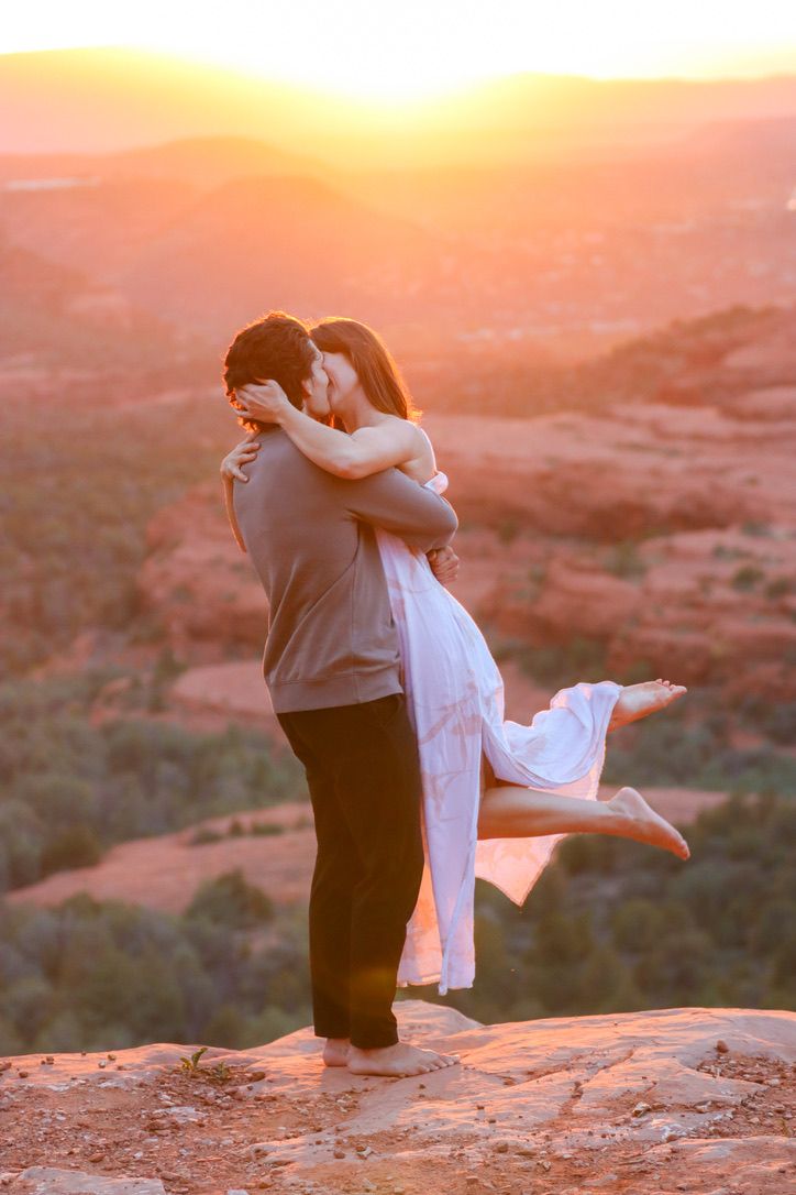 Intimate moment captured between couple on desert overlook during golden hour in Sedona Arizona.