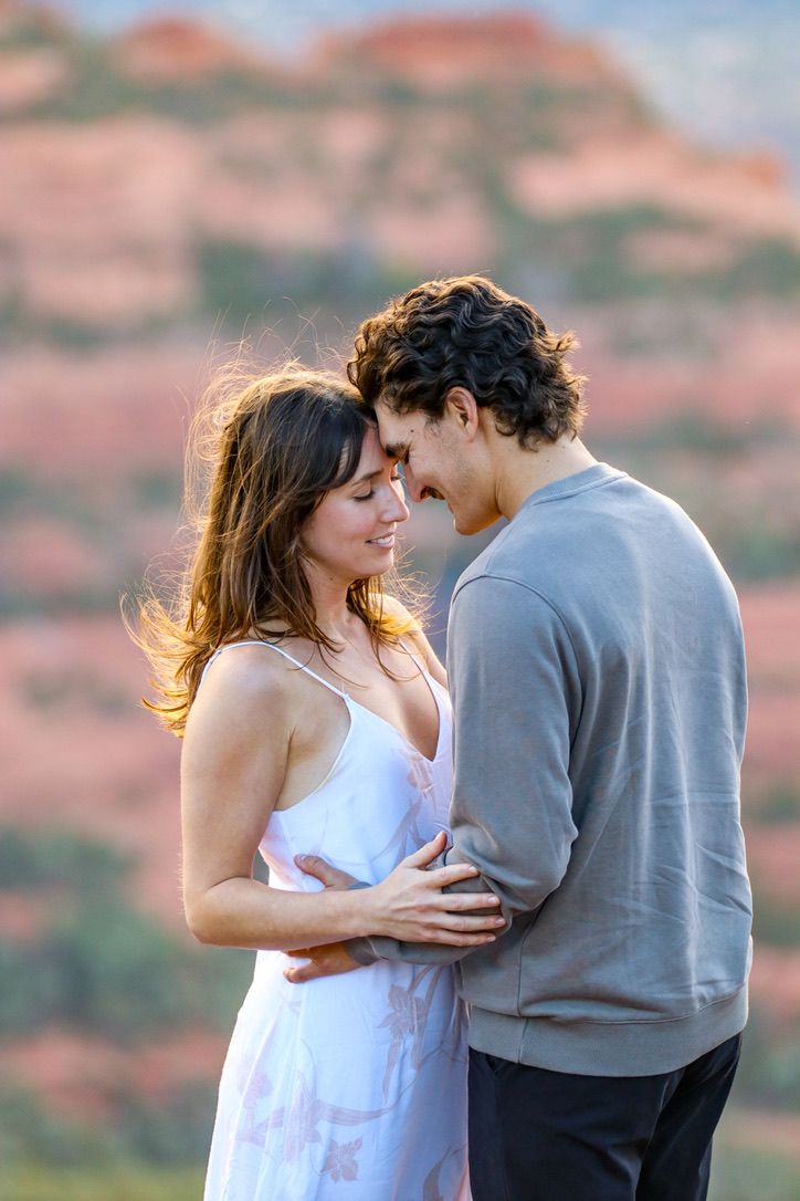 An intimate moment shared against a backdrop of stunning desert mountains during golden hour in Sedona Arizona.