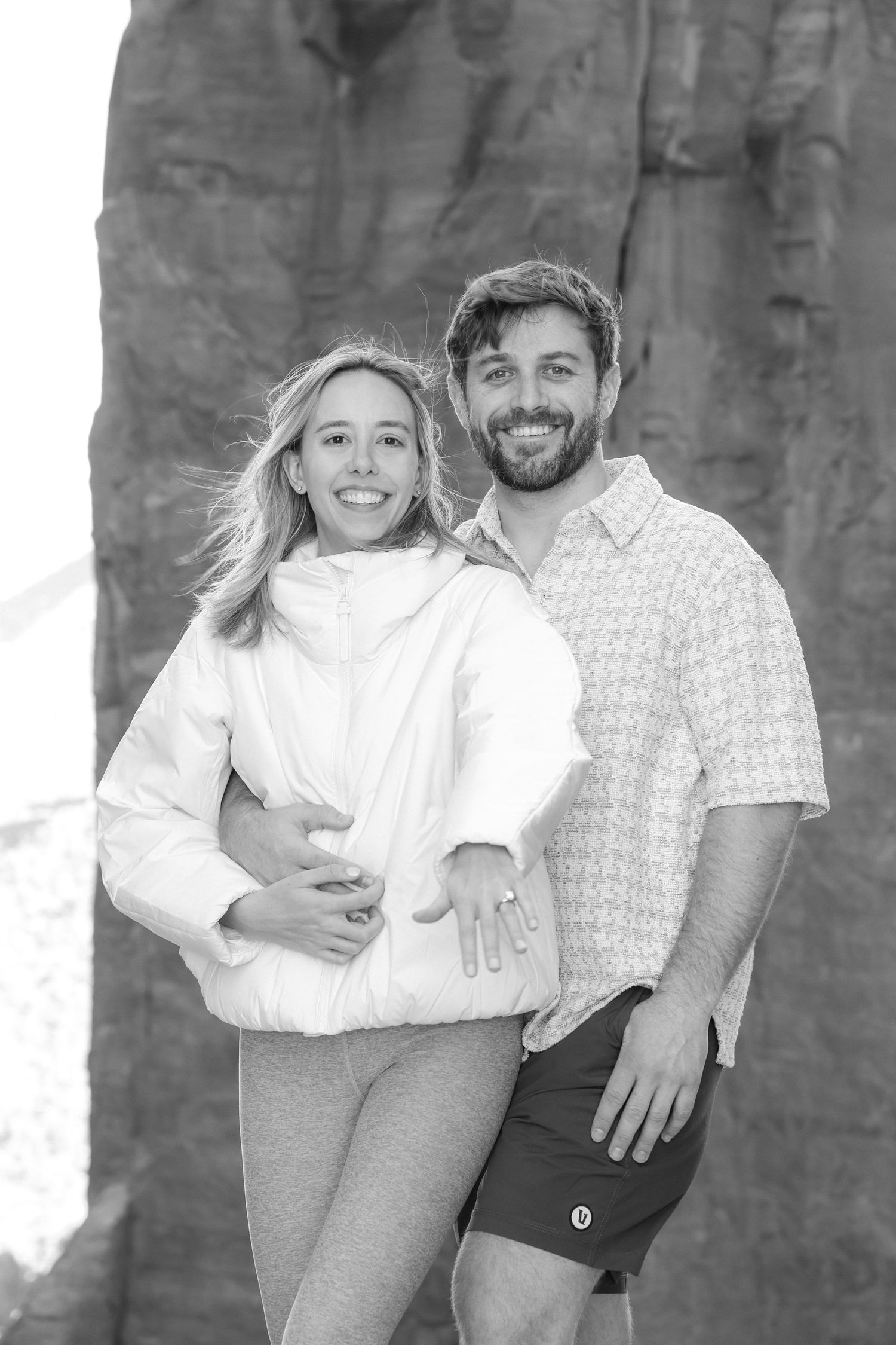 Black and white photos showing playful poses against a textured wall background.