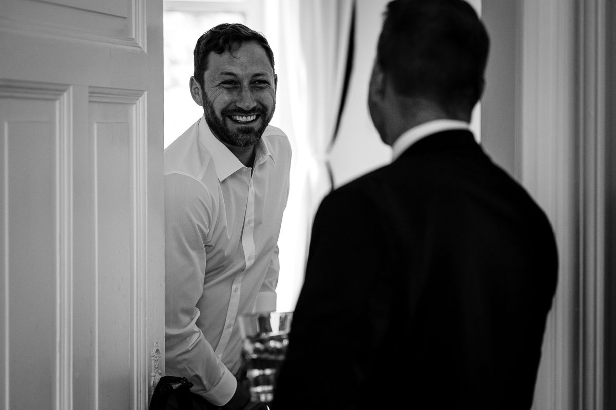 Der Bräutigam und sein Trauzeuge teilen eine humorvollen Moment während der Vorbereitung auf die Hochzeit in Siegen
