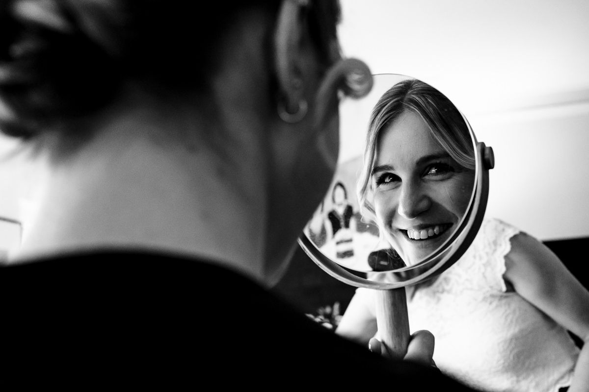 A series of black and white mirror reflections showing someone adjusting their hair and looking at themselves.