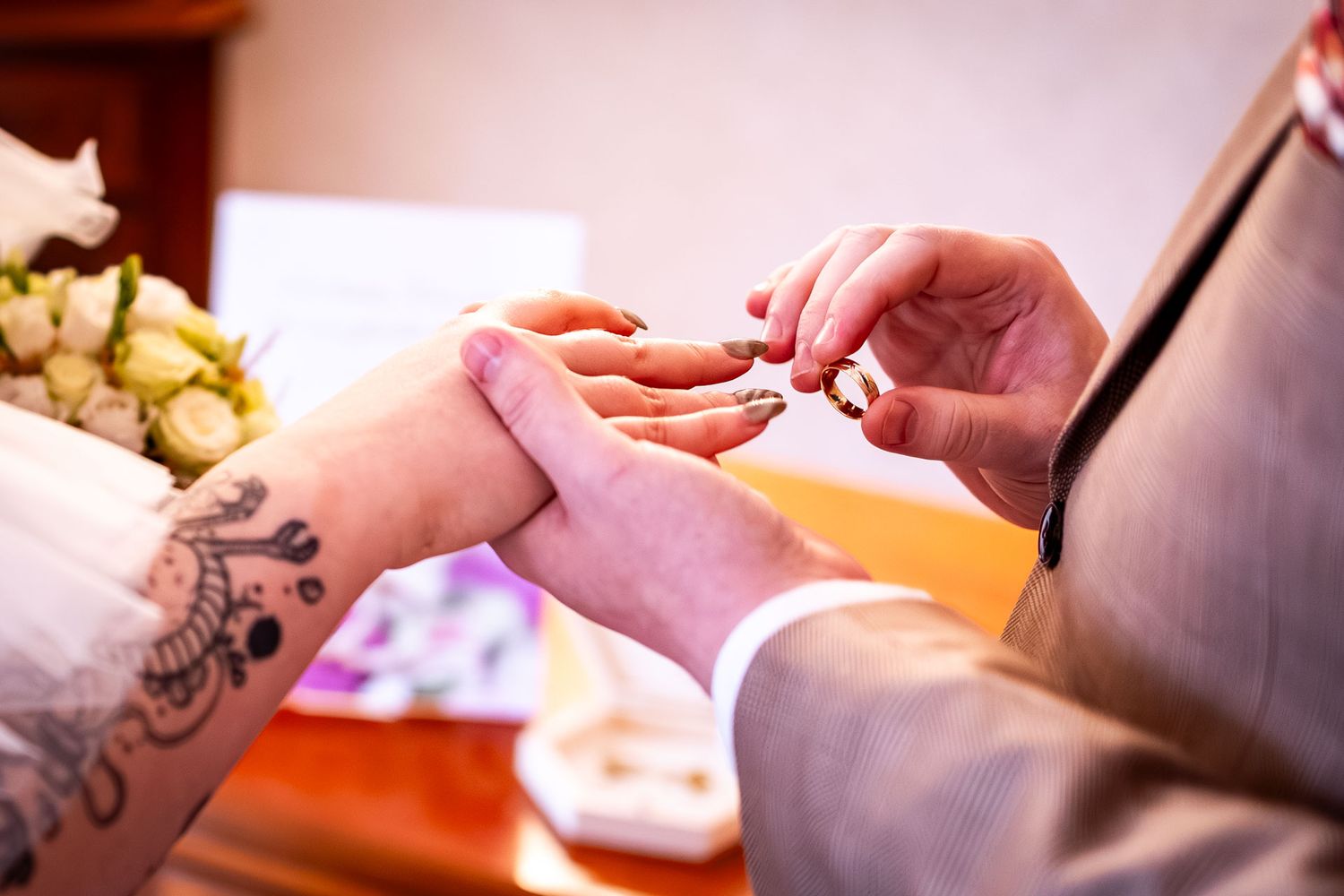 Close-up shots of hands exchanging rings during a wedding ceremony.