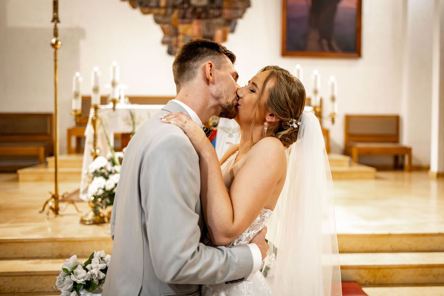 A romantic wedding ceremony moment captured in a traditional church setting with elegant candles and decor.