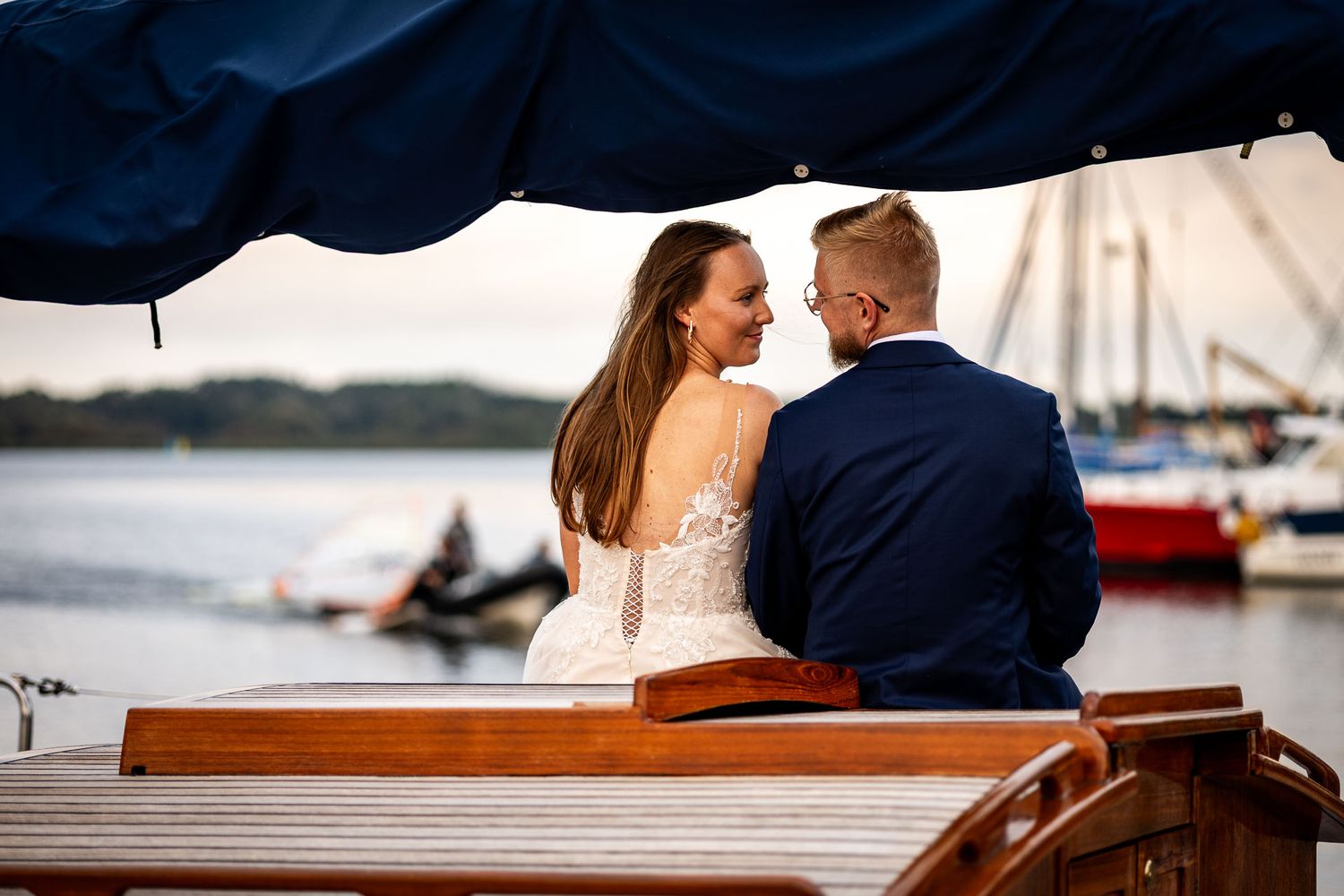 Romantic waterfront photo series with boats and docks in the background at sunset.