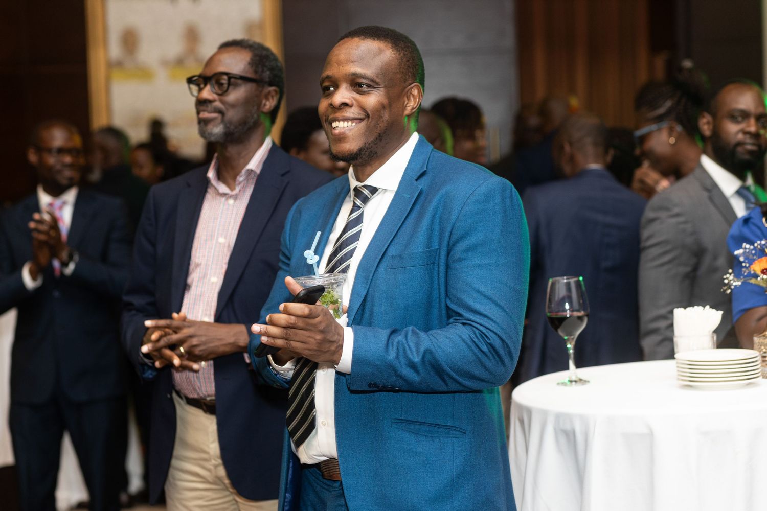 Business professionals in formal attire networking and conversing at a corporate event.