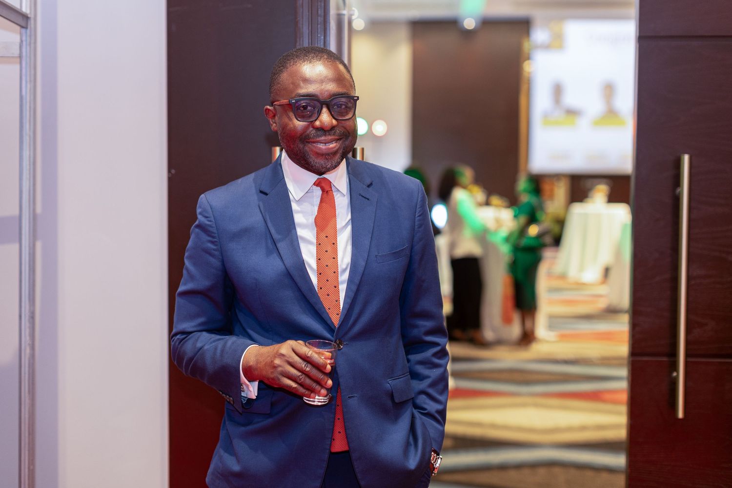 People in business attire networking and conversing at a professional conference or meeting.