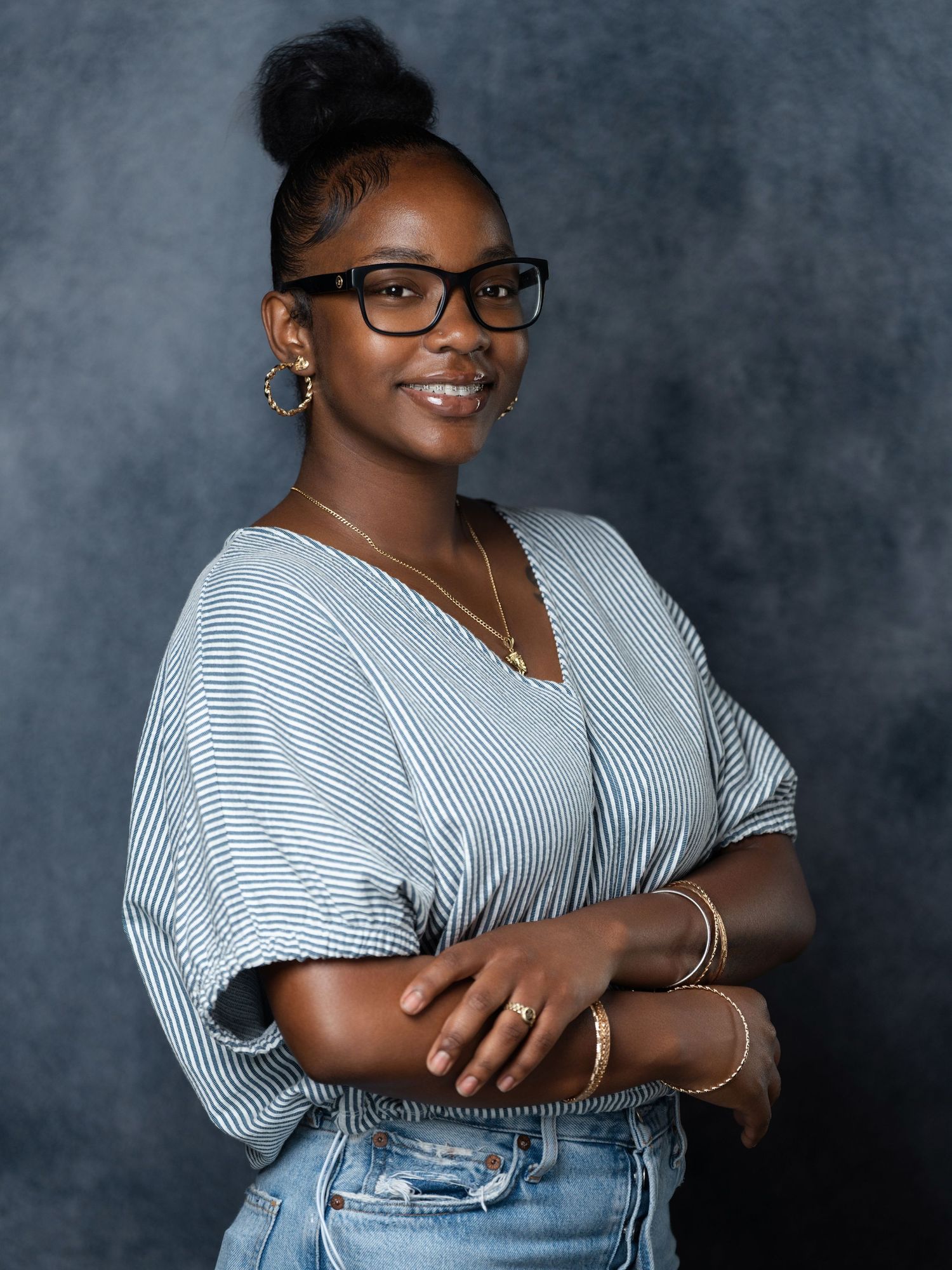 Professional portrait series showing a casual outfit with striped shirt and jeans against a dark backdrop.