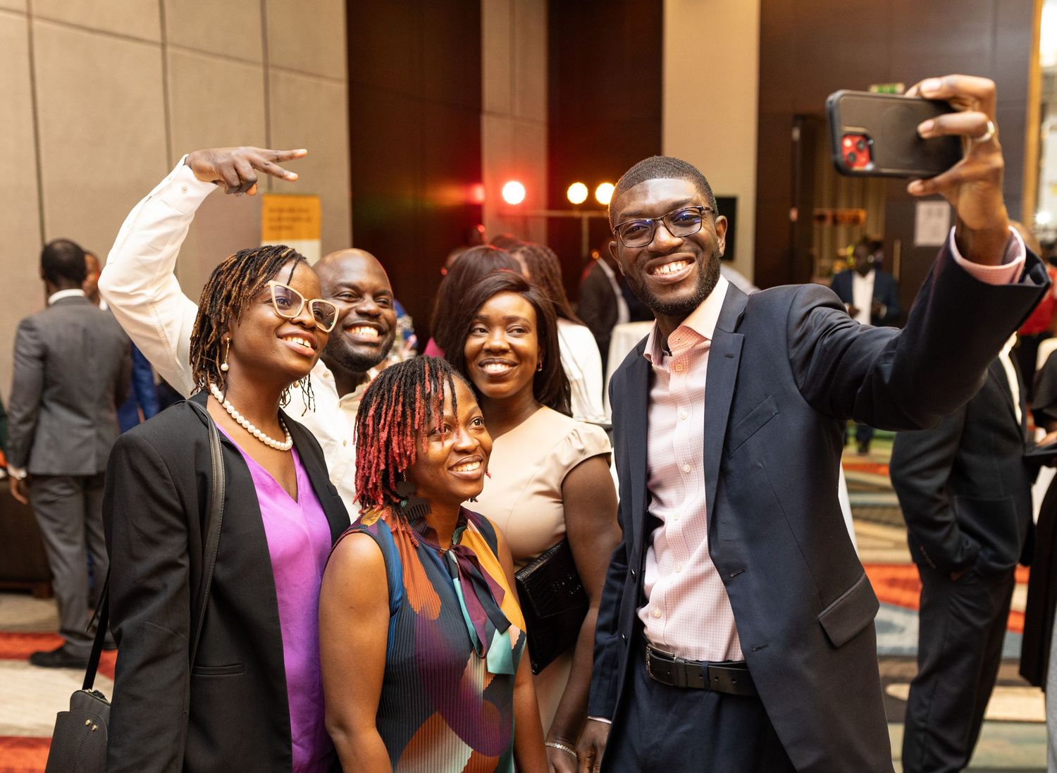 A group of people dancing and celebrating at what appears to be a wedding reception or formal party.