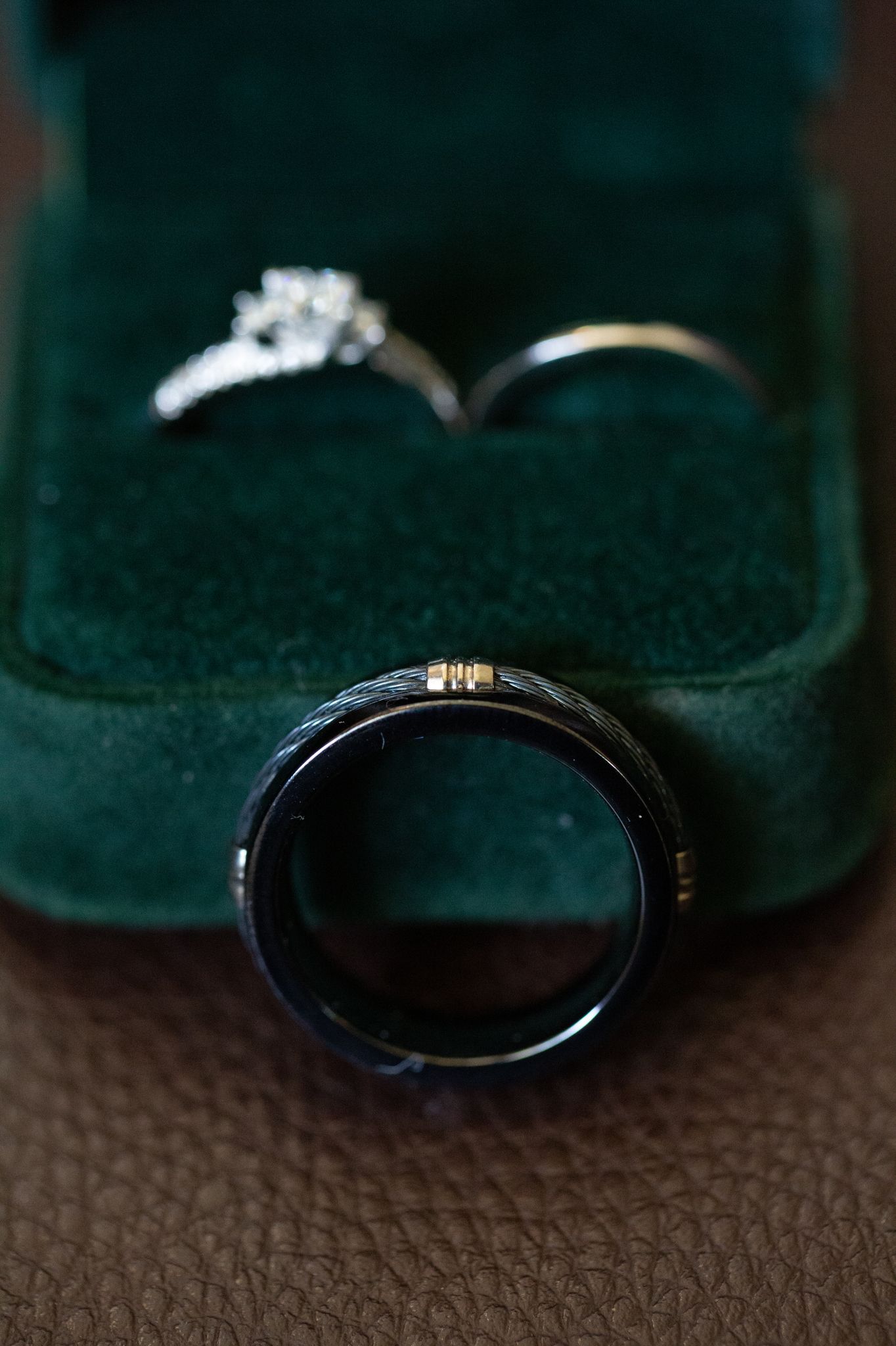Close-up macro shots showing a blue sapphire engagement ring from multiple angles on a textured surface.
