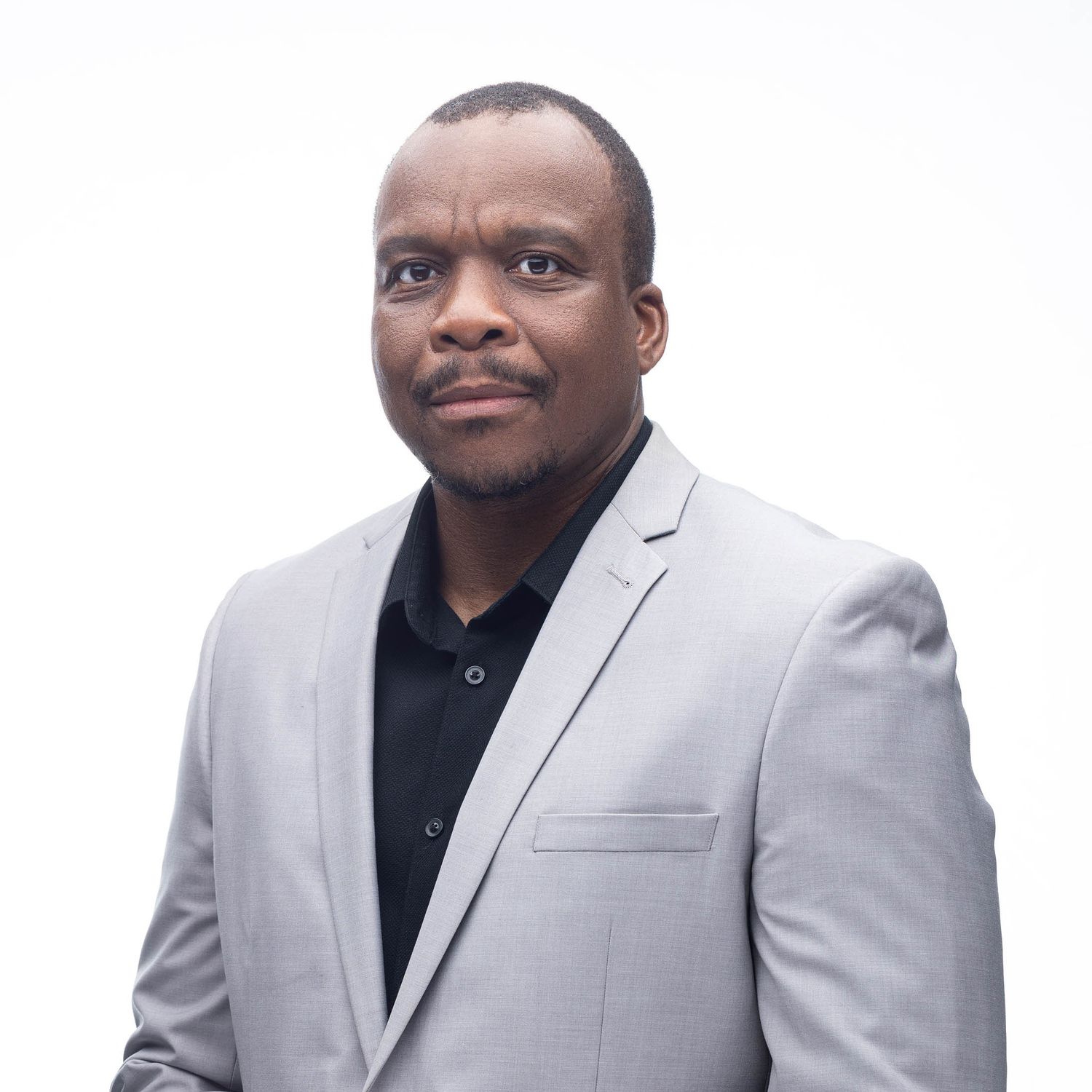 Professional headshots of businessman wearing light grey suit jacket against white background.