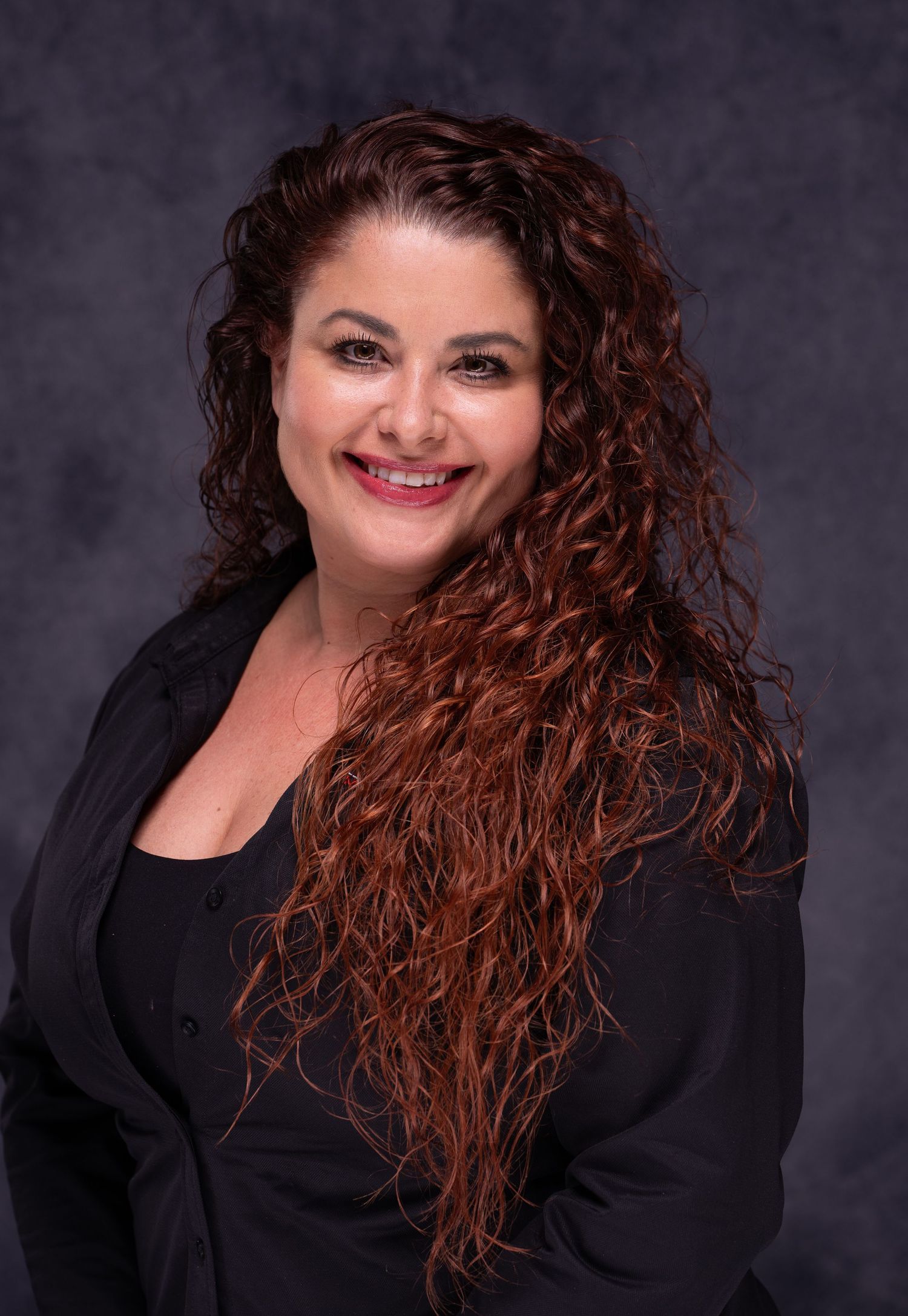 Professional headshots of woman with curly red hair against dark background.