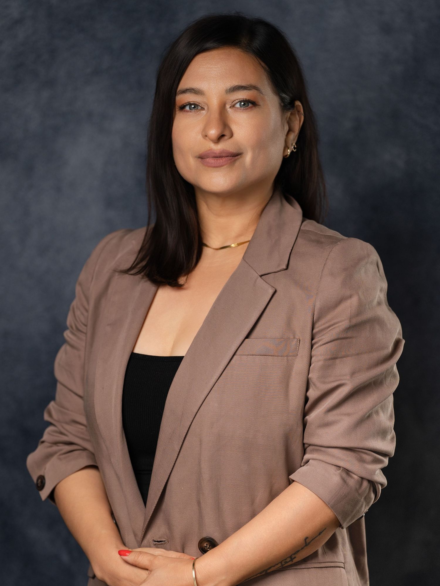 Professional studio portraits featuring a brown blazer against dark gray background.