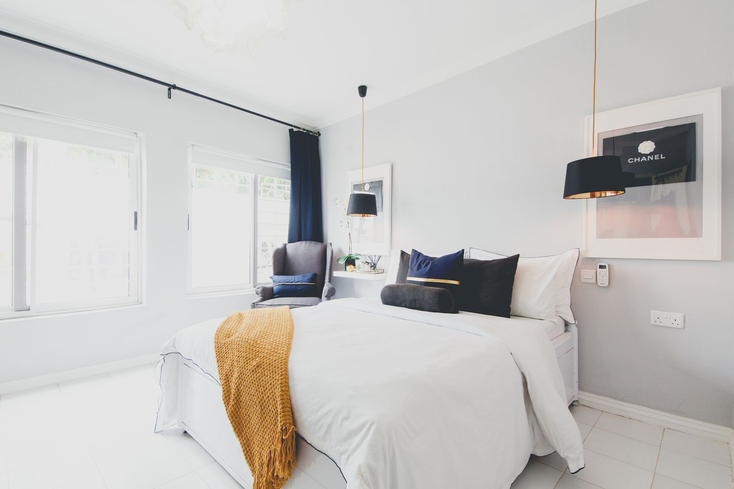 Modern minimalist white bedroom interior with simple decor and natural lighting.