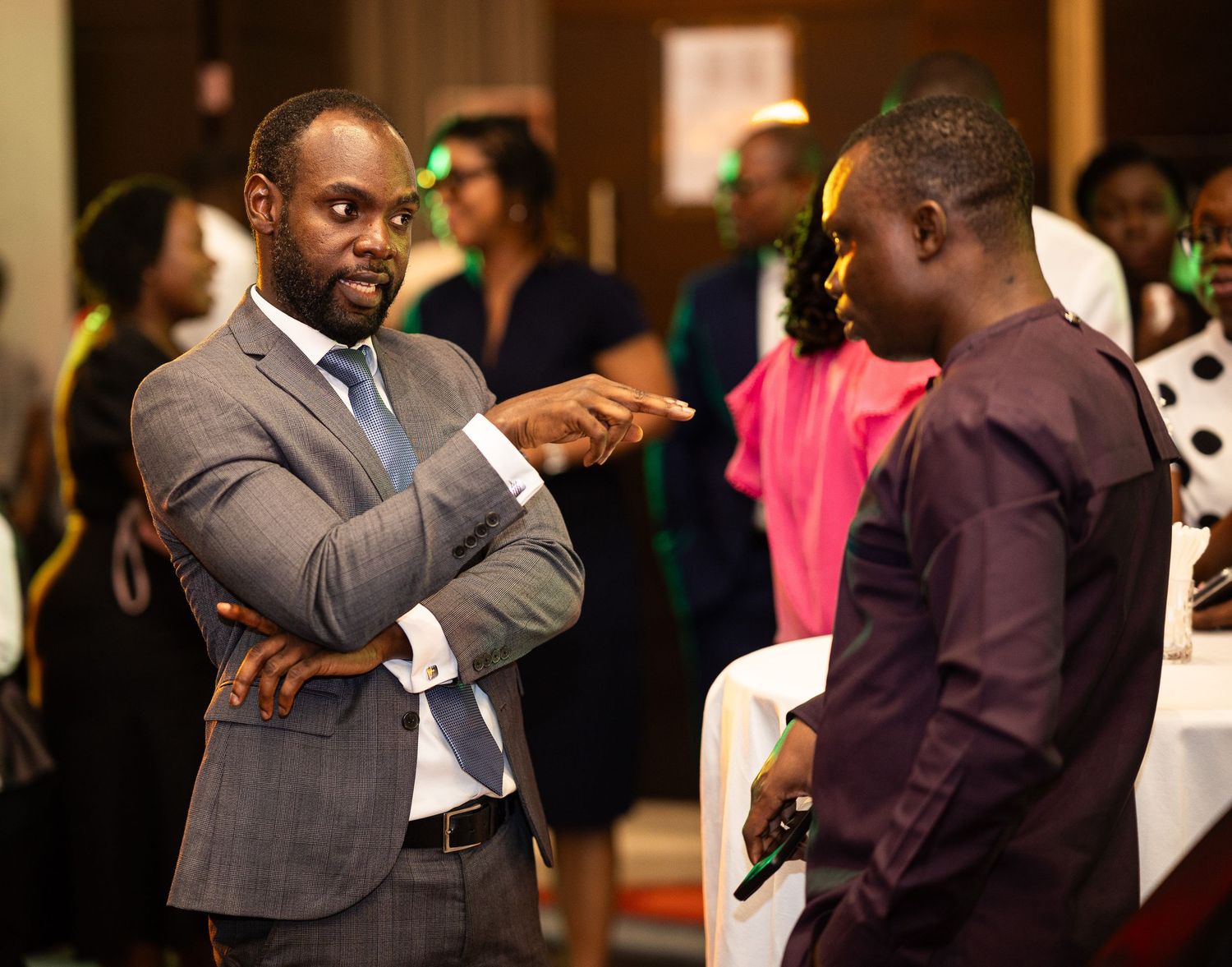 People in formal attire embrace during what appears to be a social gathering or celebration event.