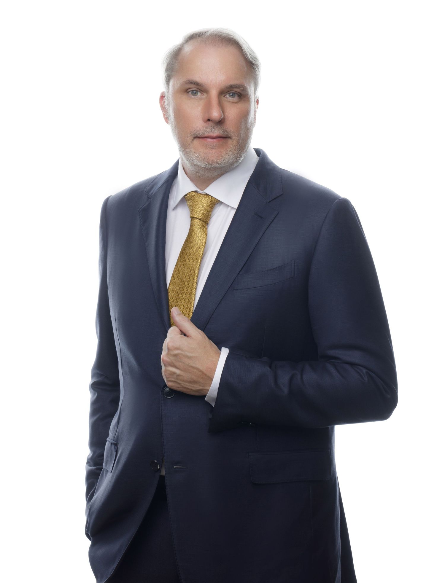Business portraits in navy suit and gold tie against white background.